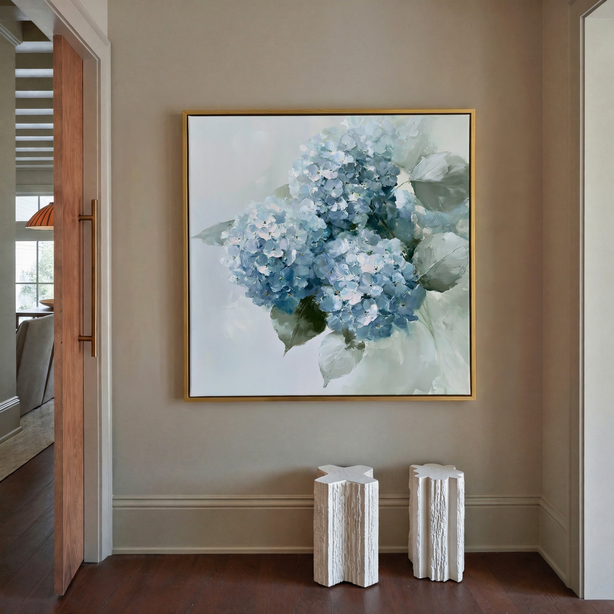 dusty blue hydrangea bouquet with pale green canvas wall art in a gold frame in a styled room setting