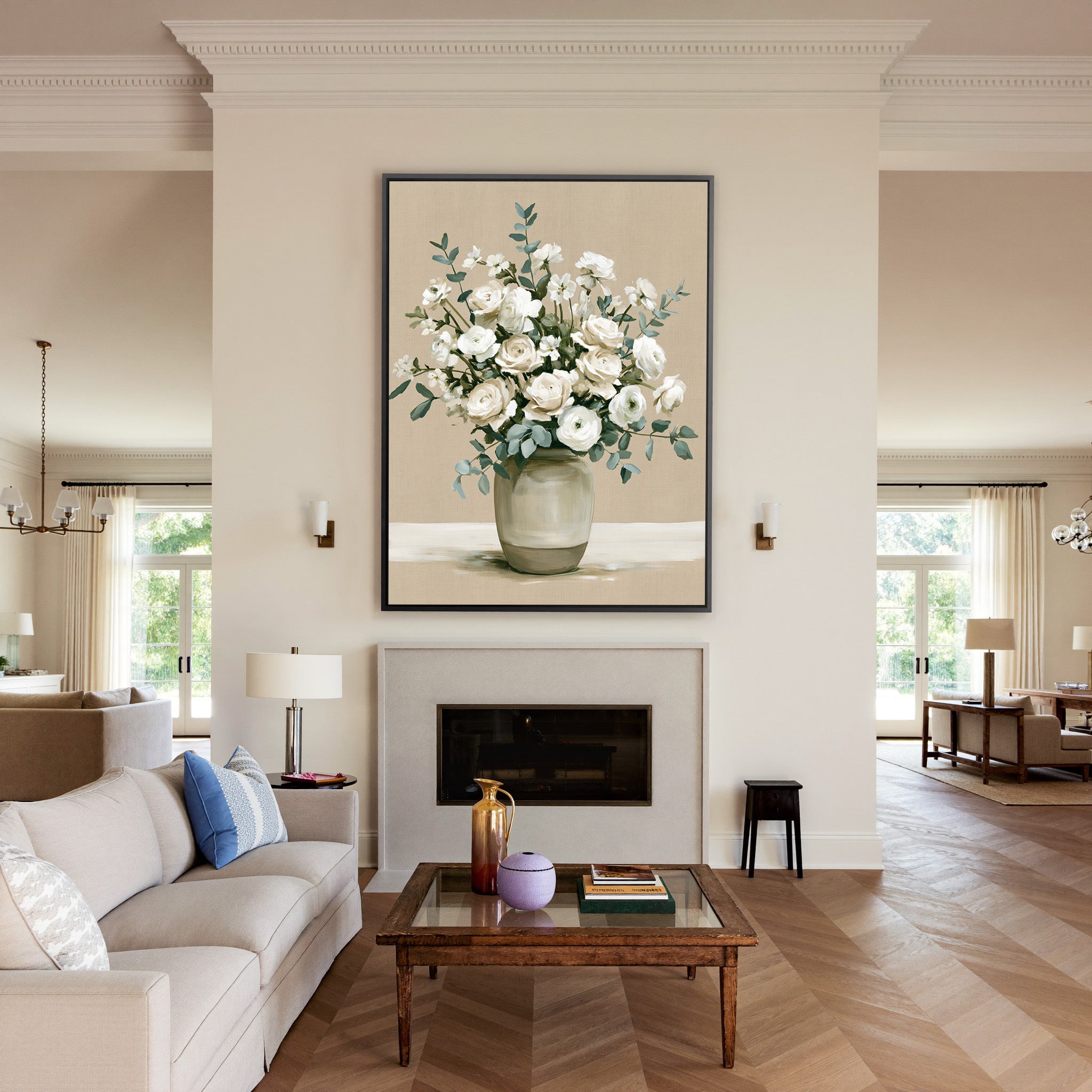 white roses and ranunculus in a glass vase canvas wall art in a black frame above a mantel