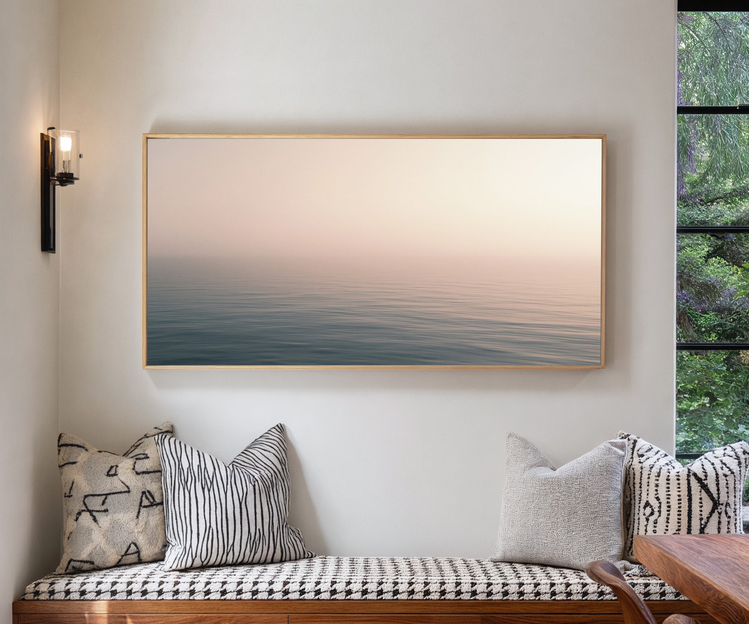 soft blush and blue seascape canvas wall art in a natural wood frame in a living room