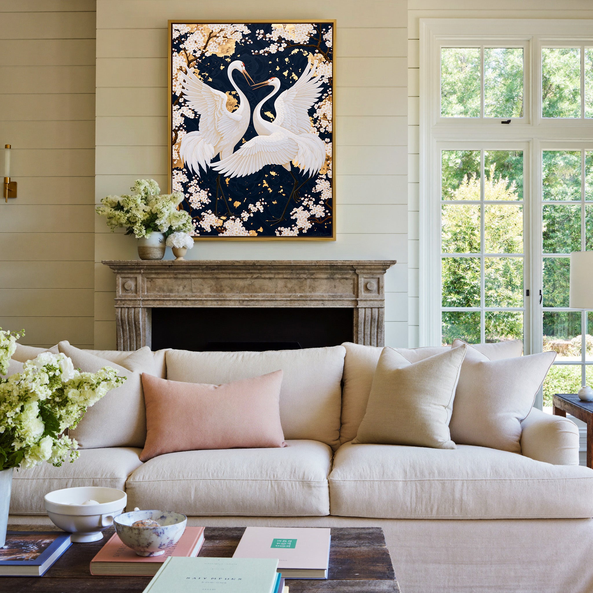 white crane pair among cherry blossoms on a canvas wall art in a gold frame above a mantel