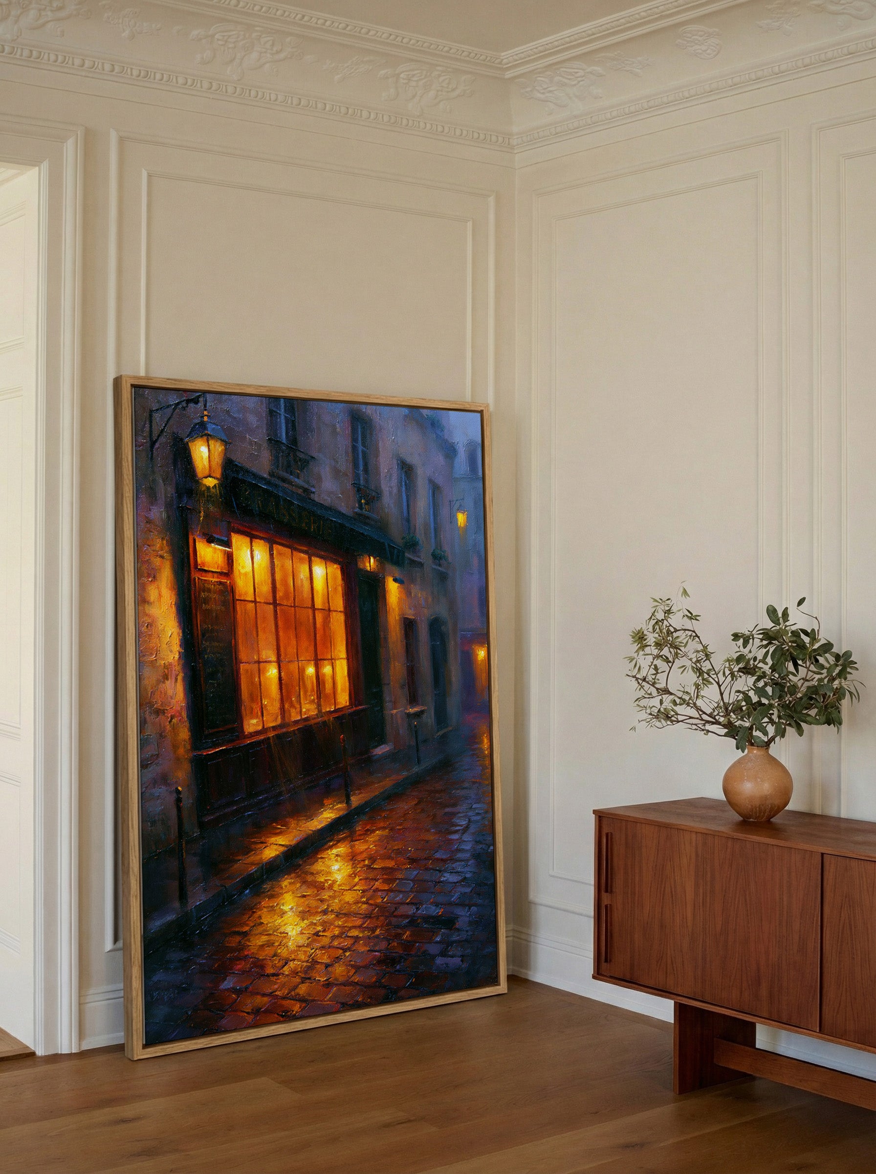 rain soaked parisian street with warm window canvas wall art in an oak frame in a styled room setting