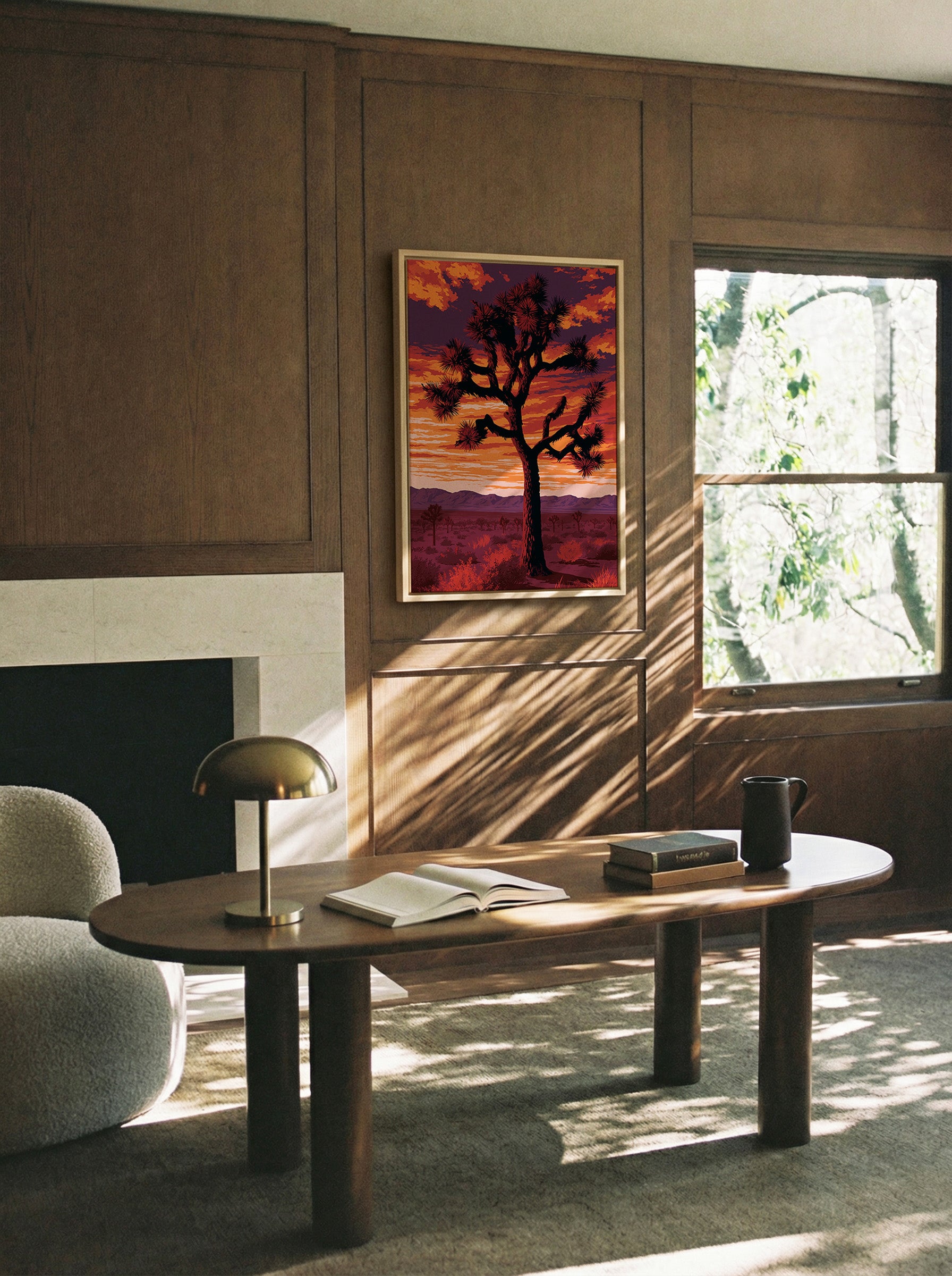 silhouetted joshua tree at sunset with orange canvas wall art in a natural wood frame in a styled room setting