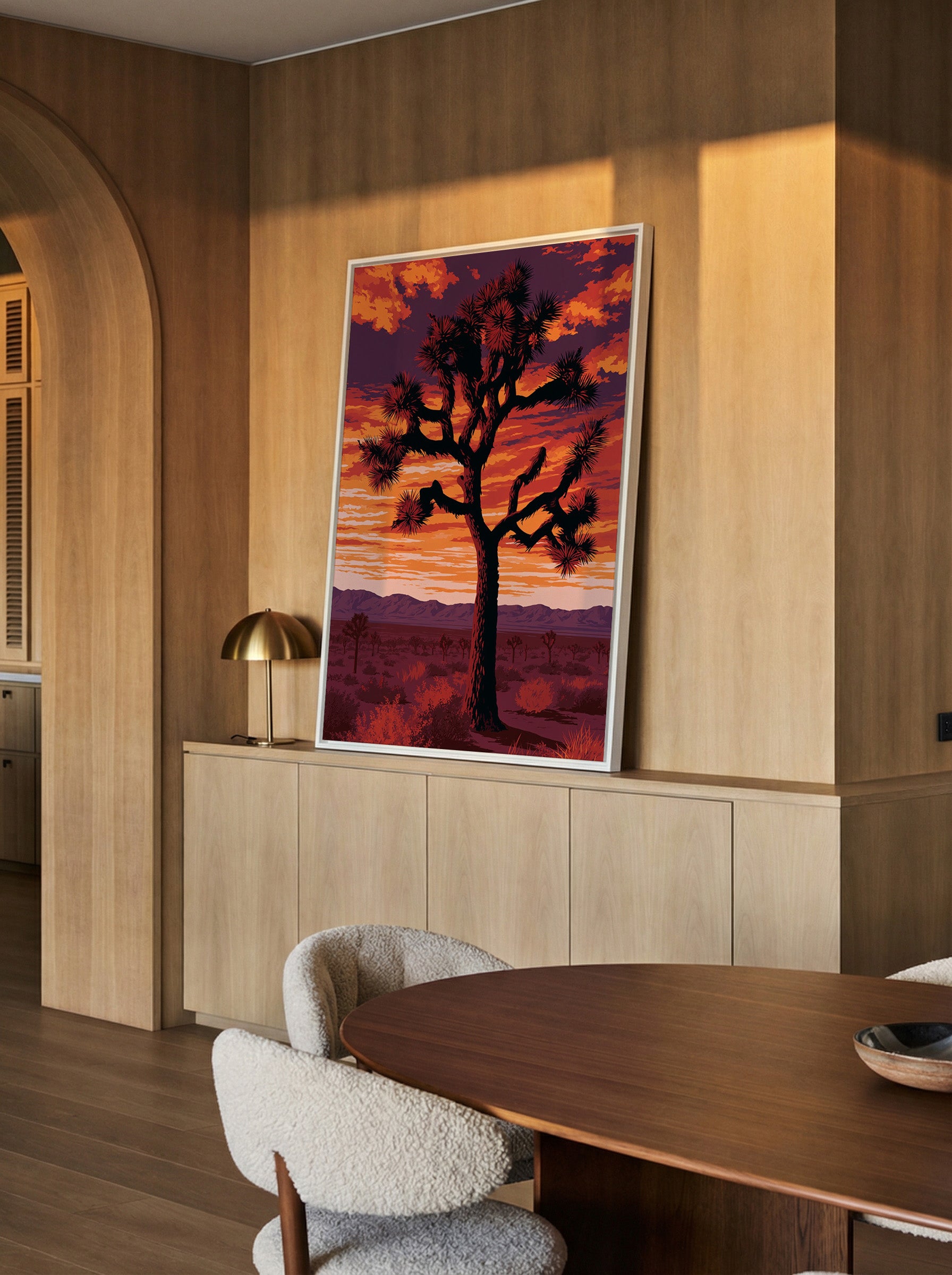 silhouetted joshua tree at sunset with orange canvas wall art in a white frame in a styled room setting