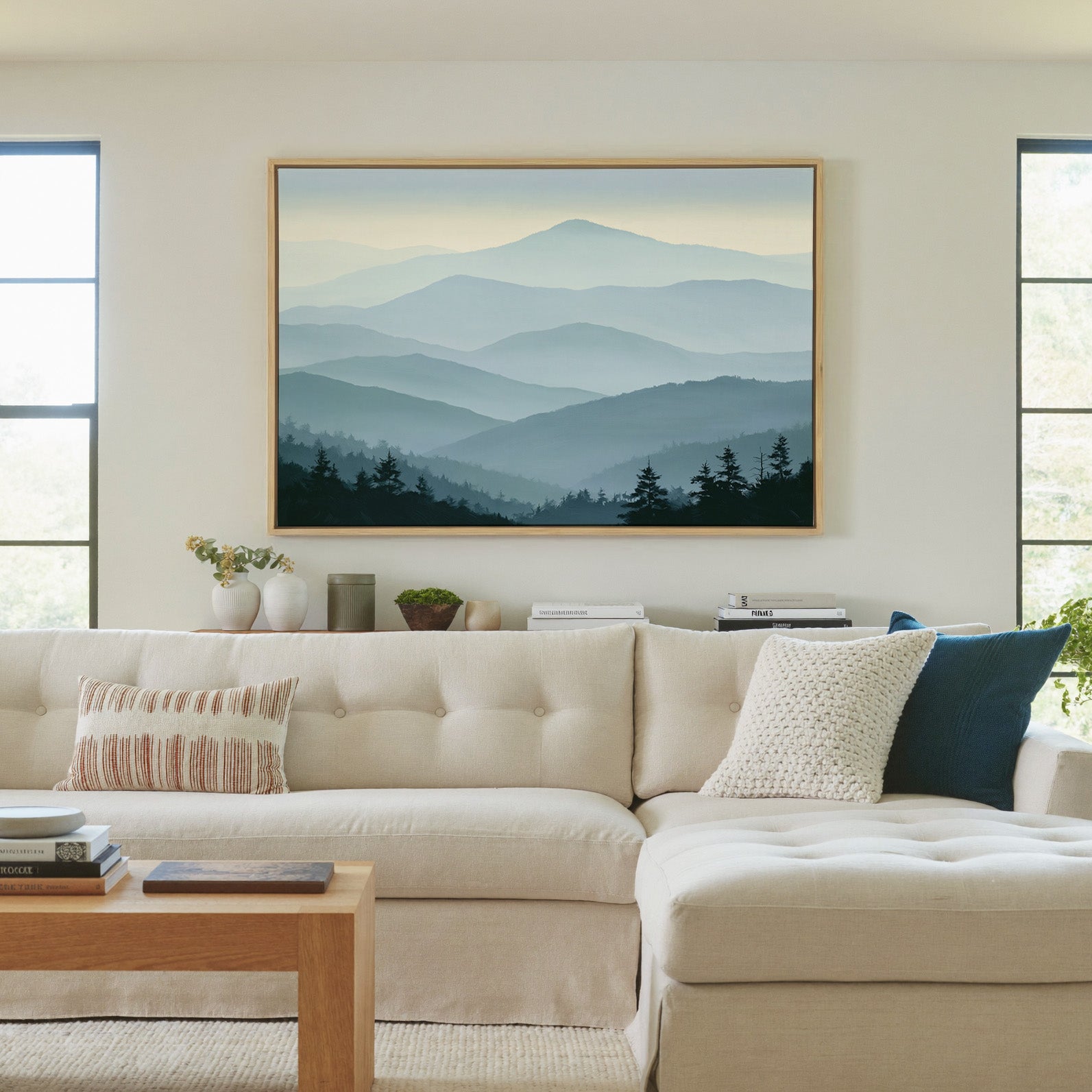 layered blue mountain ridges with mist and dark canvas wall art in a natural wood frame in a living room