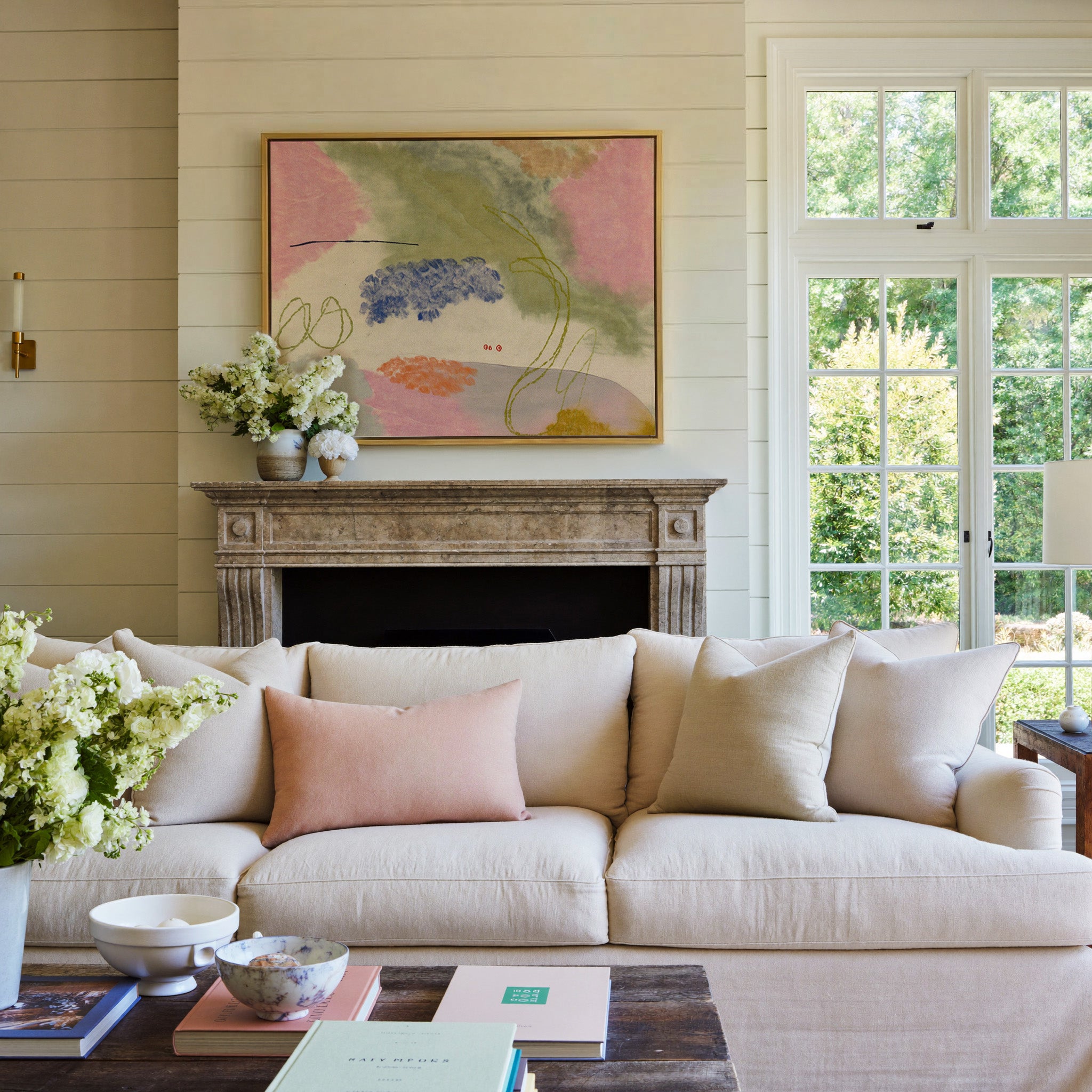 soft pink, green, blue, and orange abstract canvas wall art in a gold frame above a mantel