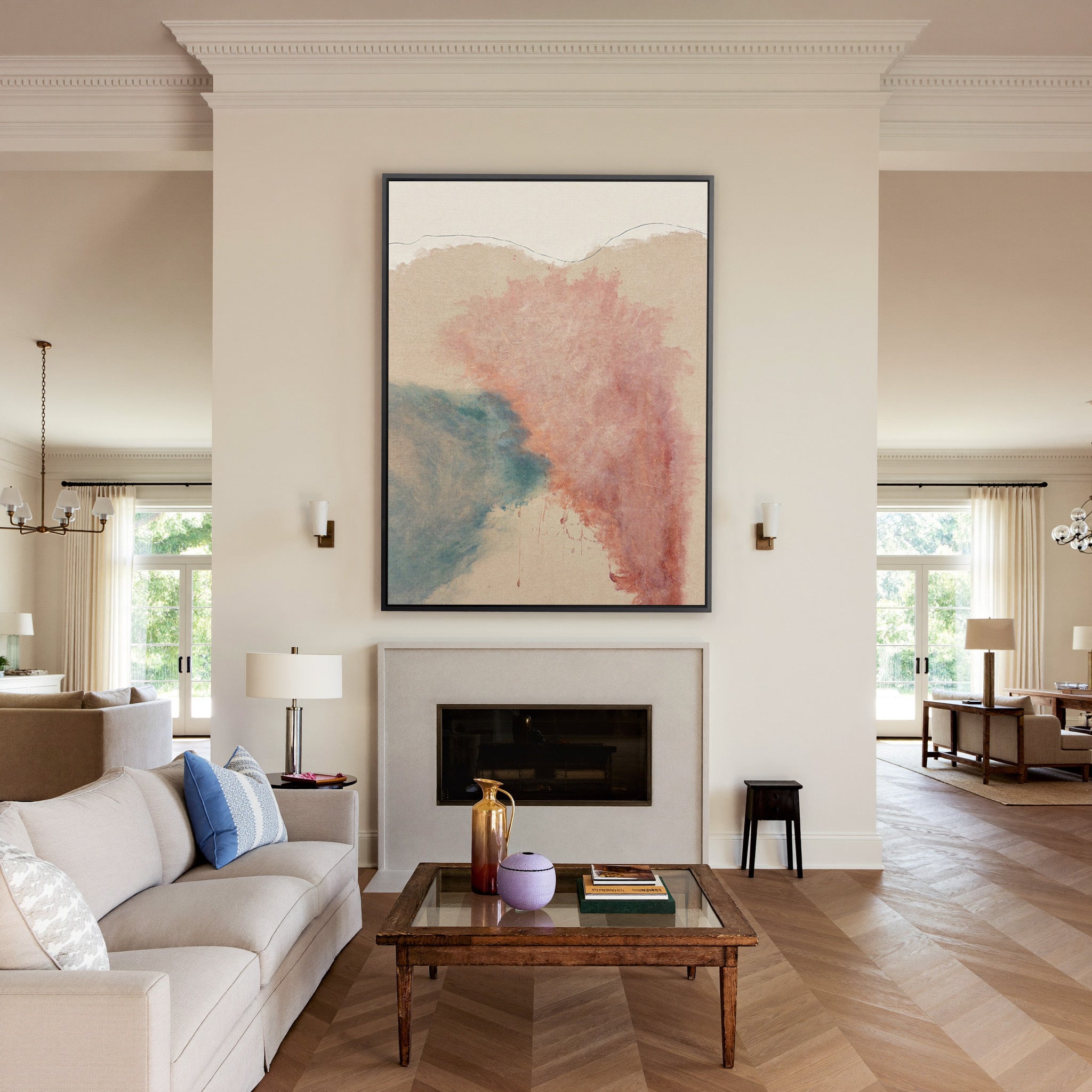 blush pink and teal abstract with soft clouded canvas wall art in a black frame above a mantel