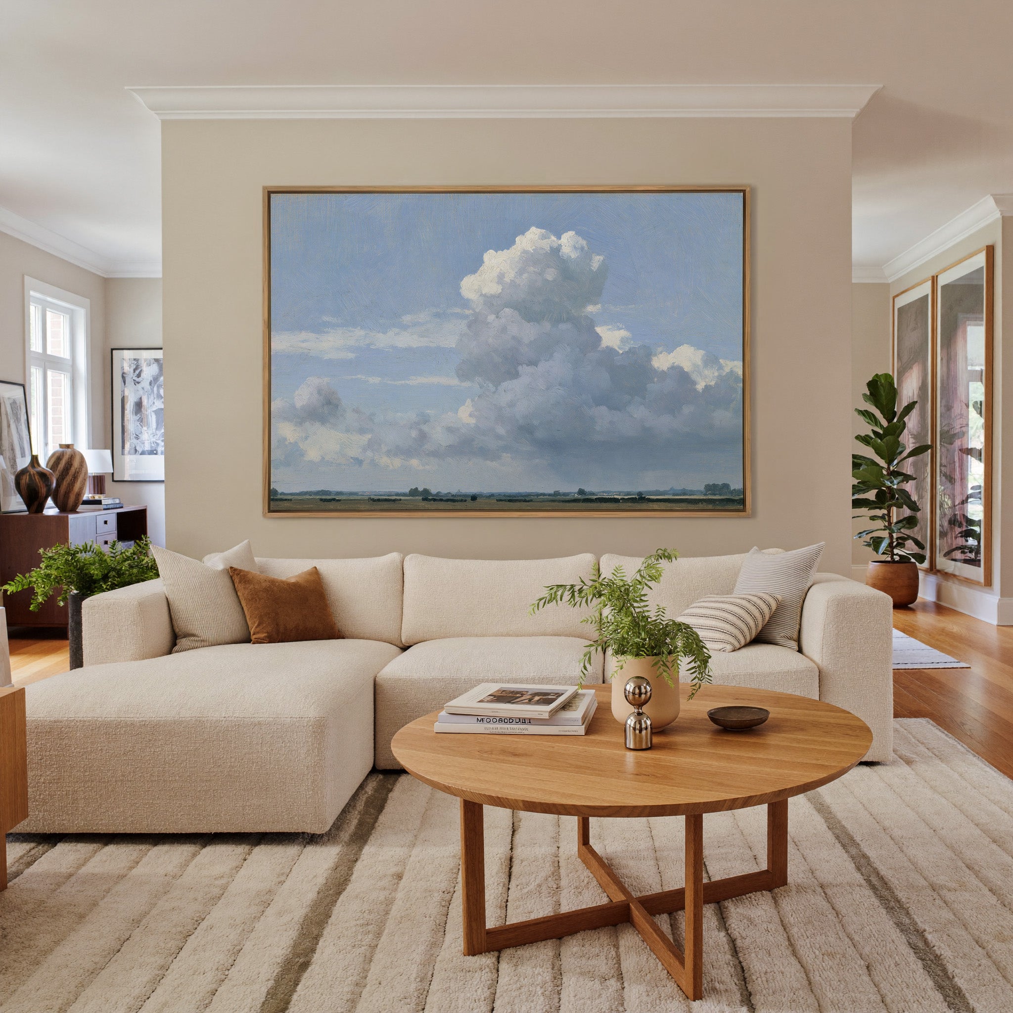 vast blue sky with towering white cloud over a canvas wall art in an oak frame in a living room