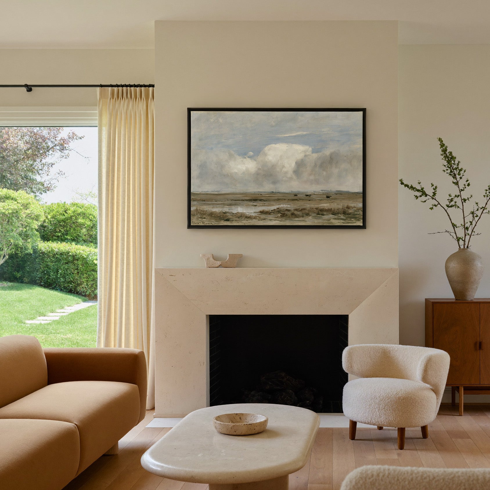 pale countryside with wet fields and a broad canvas wall art in a black frame above a mantel
