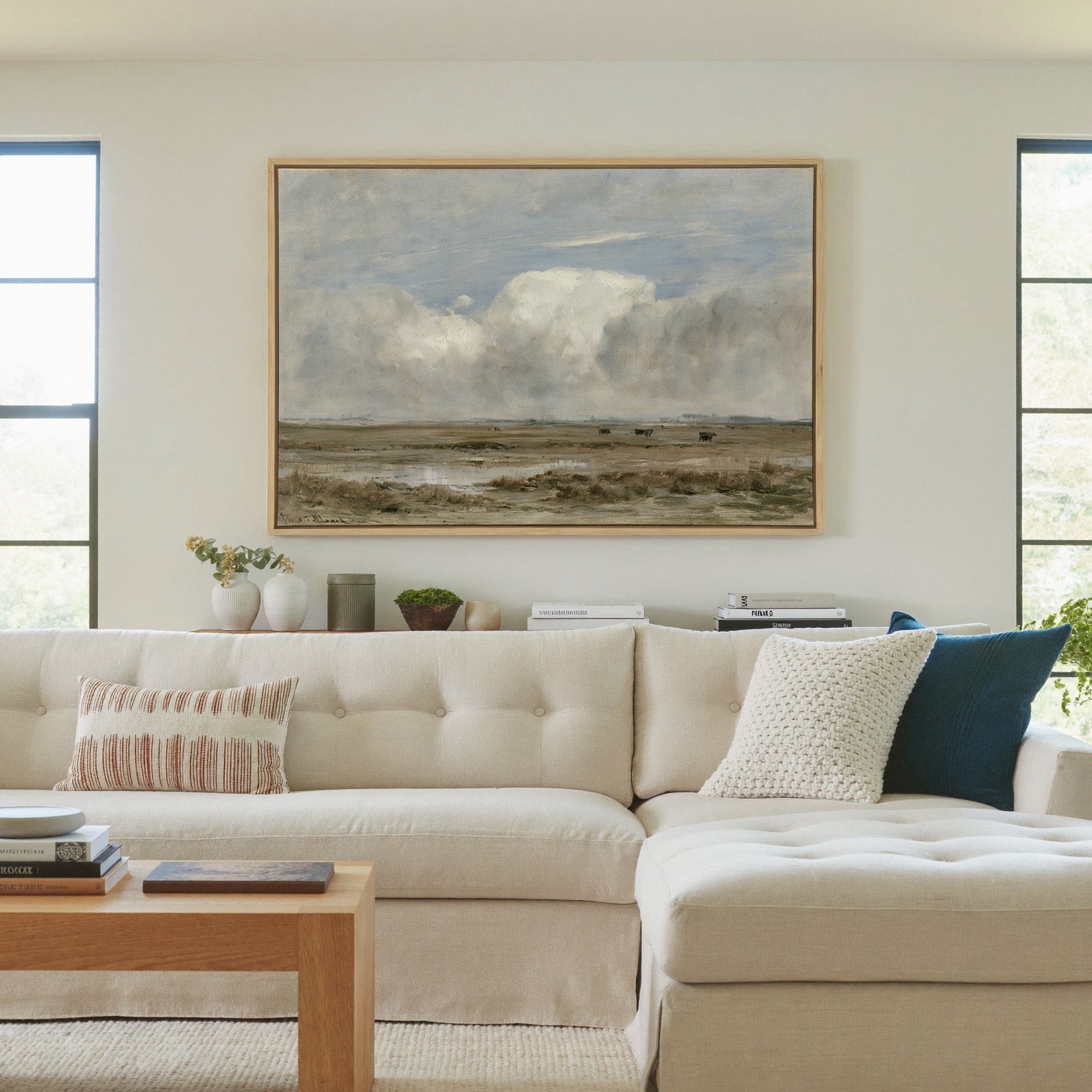 pale countryside with wet fields and a broad canvas wall art in a natural wood frame in a living room