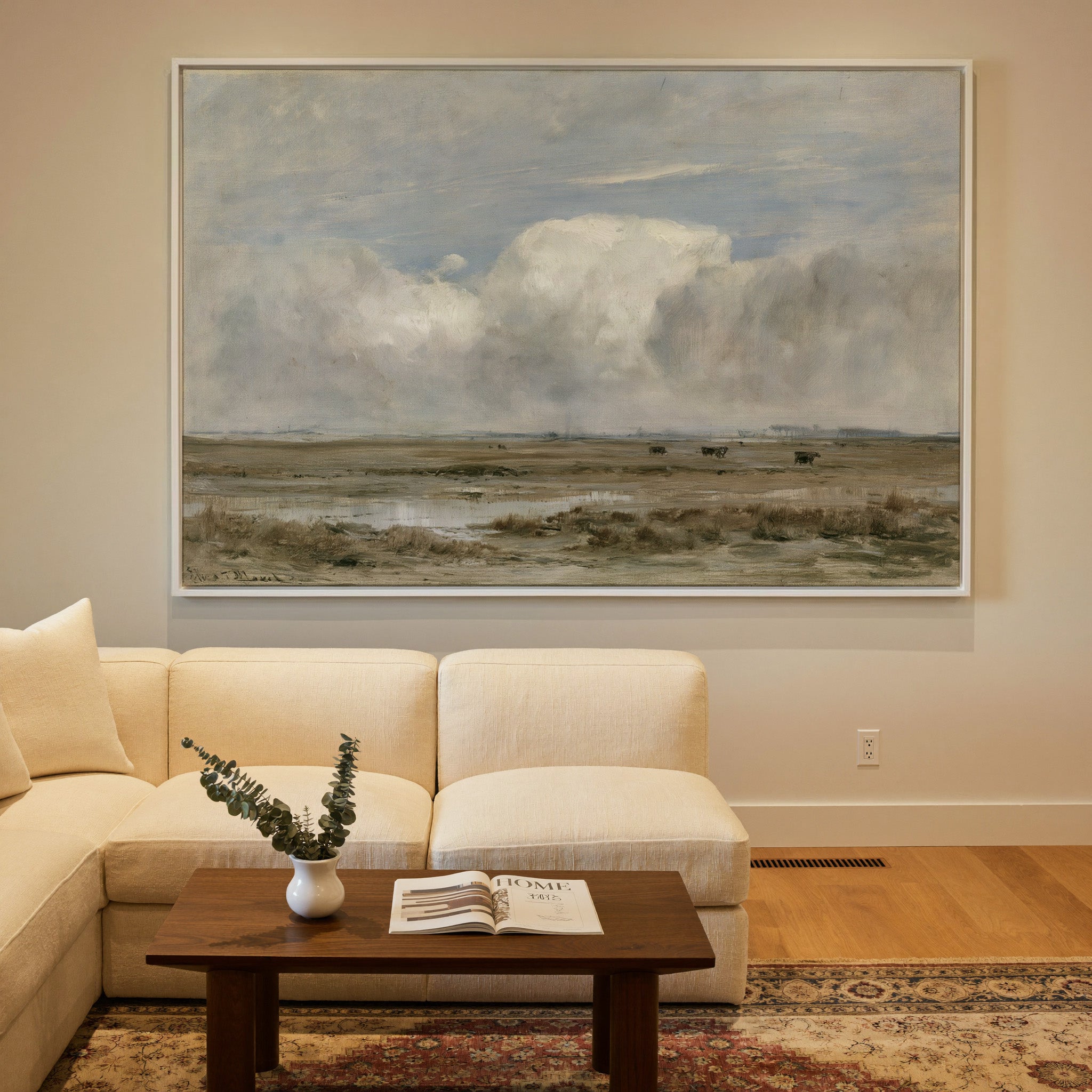pale countryside with wet fields and a broad canvas wall art in a white frame in a styled room setting