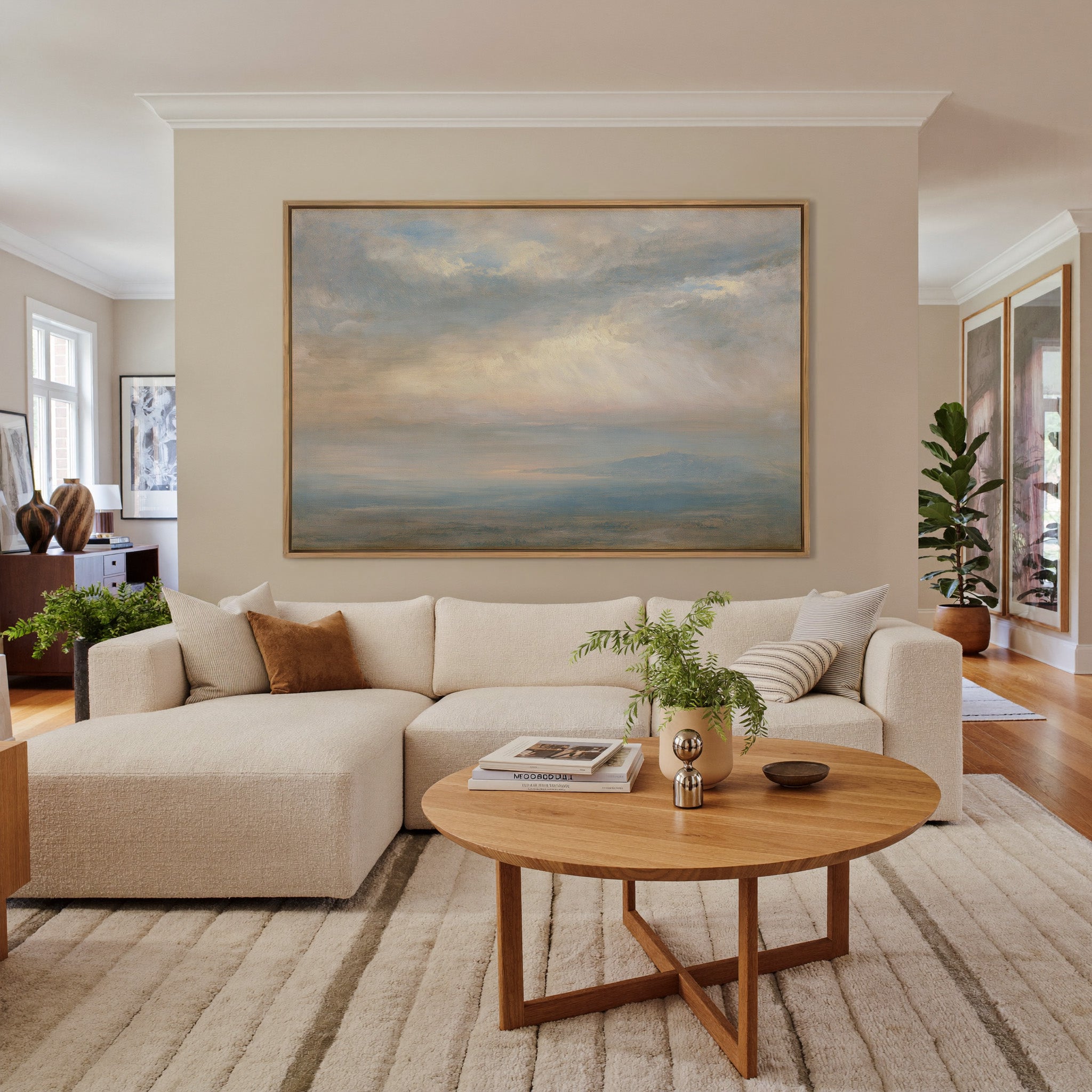 pale cloudscape with sea mist and a low distant canvas wall art in an oak frame in a living room