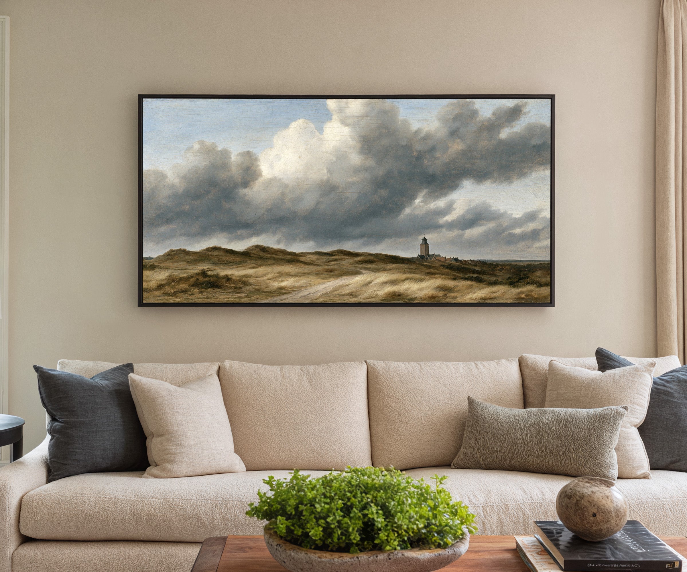 low dunes under towering wind driven clouds canvas wall art in a black frame in a styled room setting
