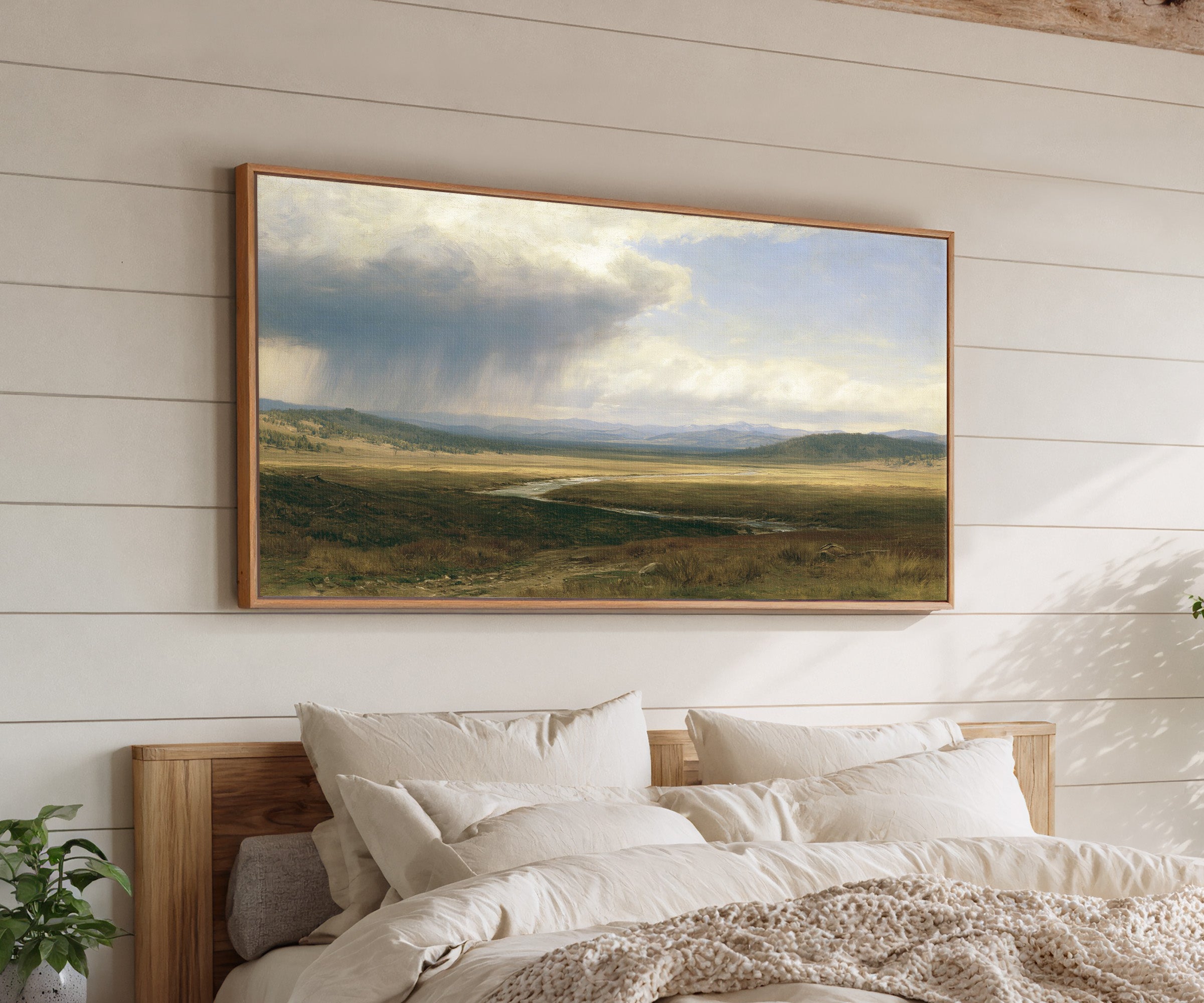 broad plain under a split storm sky canvas wall art in an oak frame above a bed