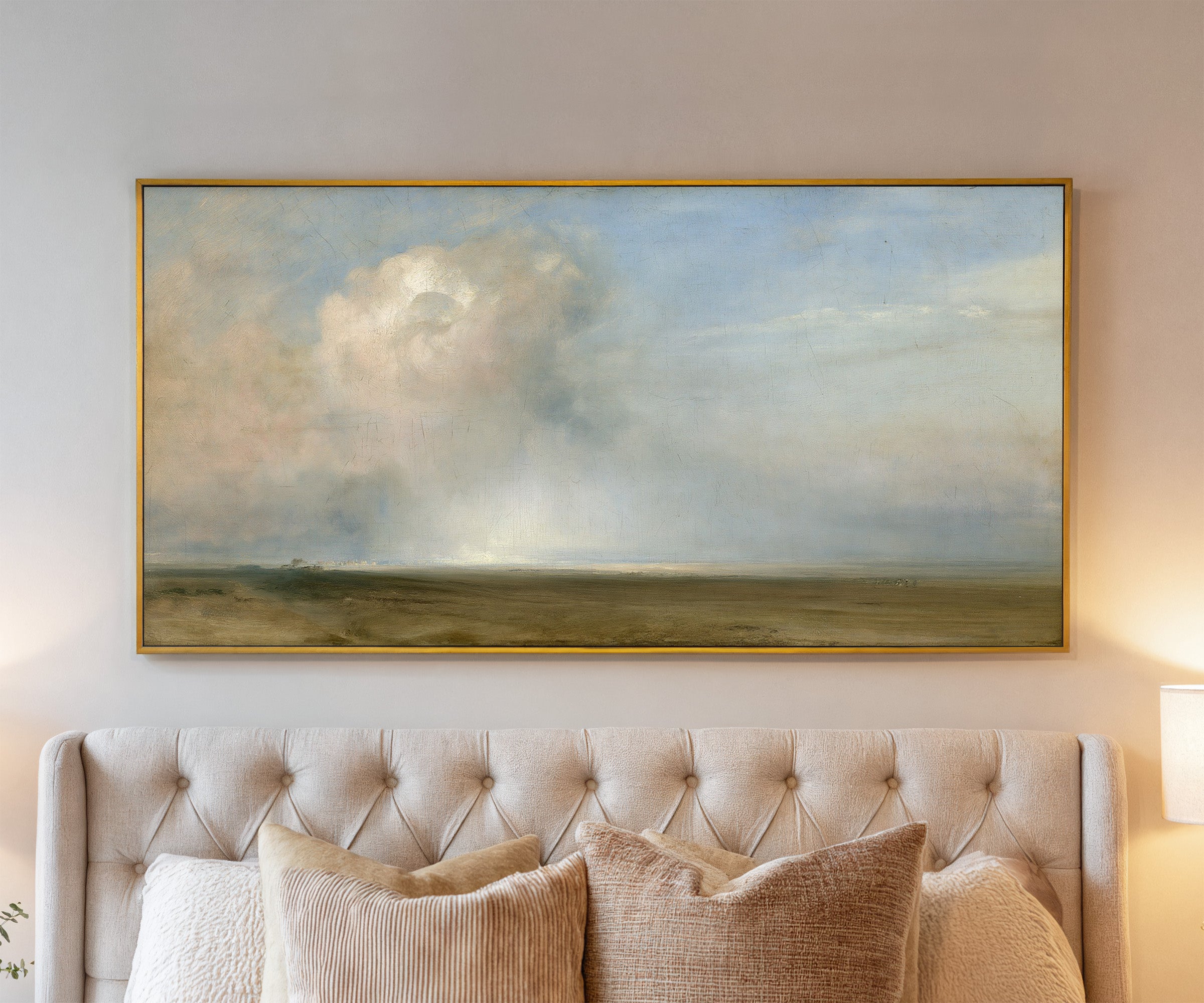 single towering cumulus cloud over a low plain canvas wall art in a gold frame above a bed