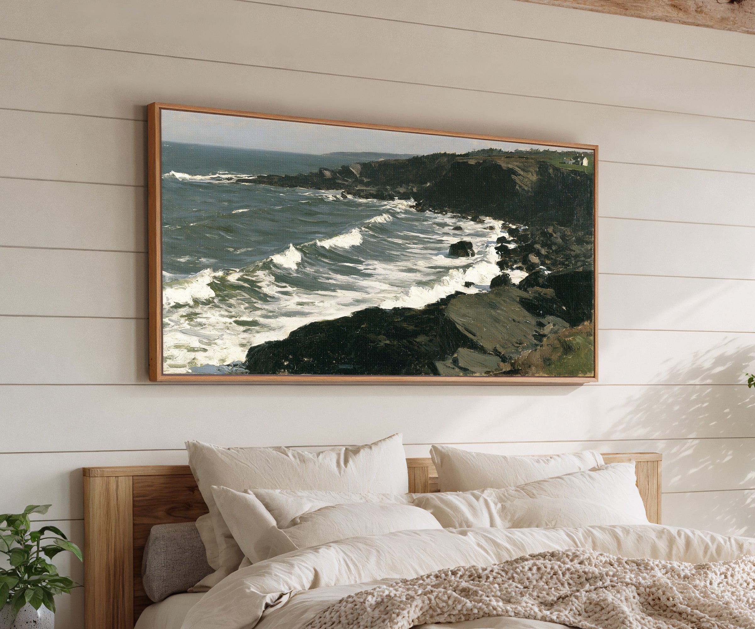 dark headland with white surf canvas wall art in an oak frame above a bed