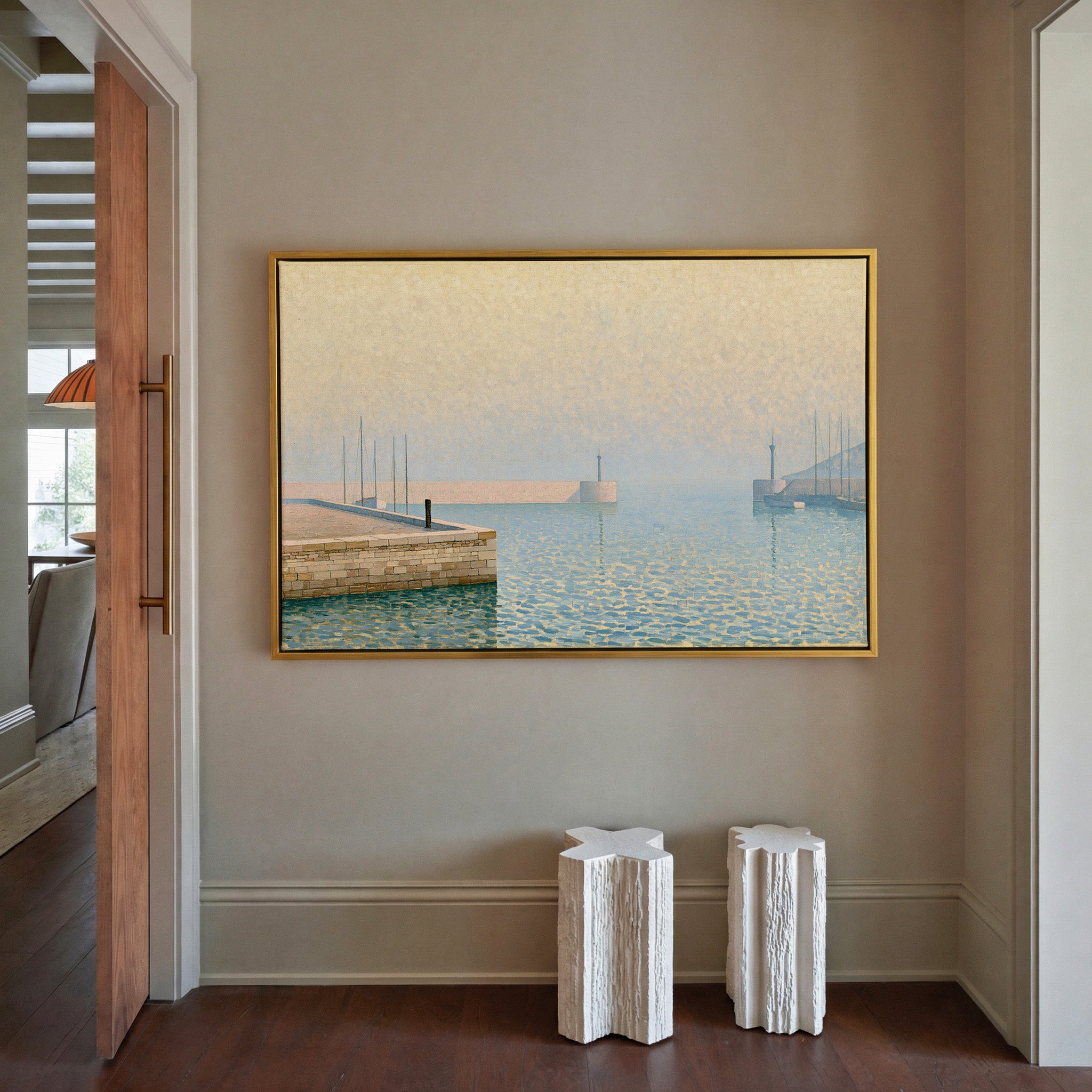 pale geometric harbor with stone pier and soft canvas wall art in a gold frame in a styled room setting