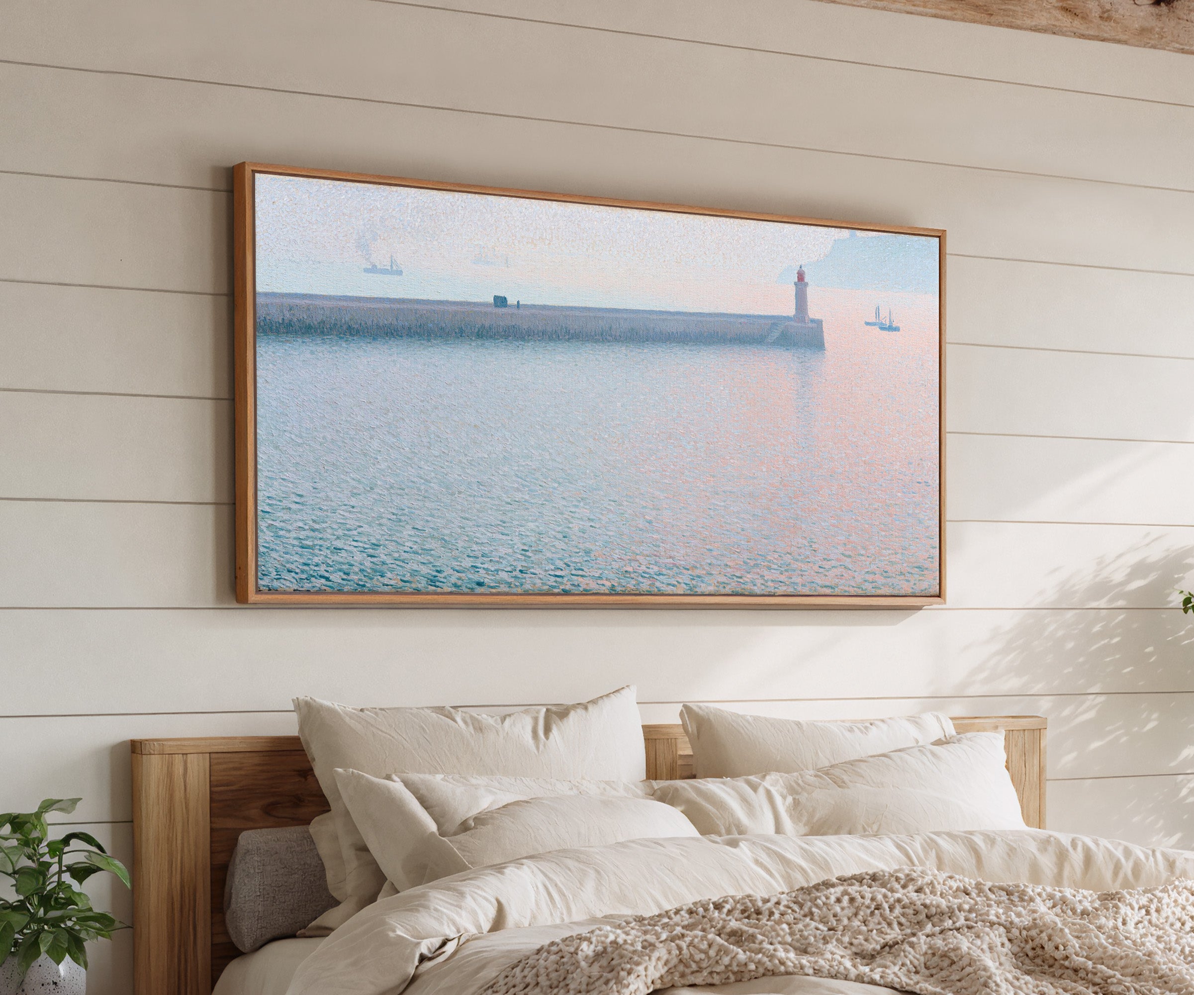 long harbor wall with a lighthouse and soft canvas wall art in an oak frame above a bed