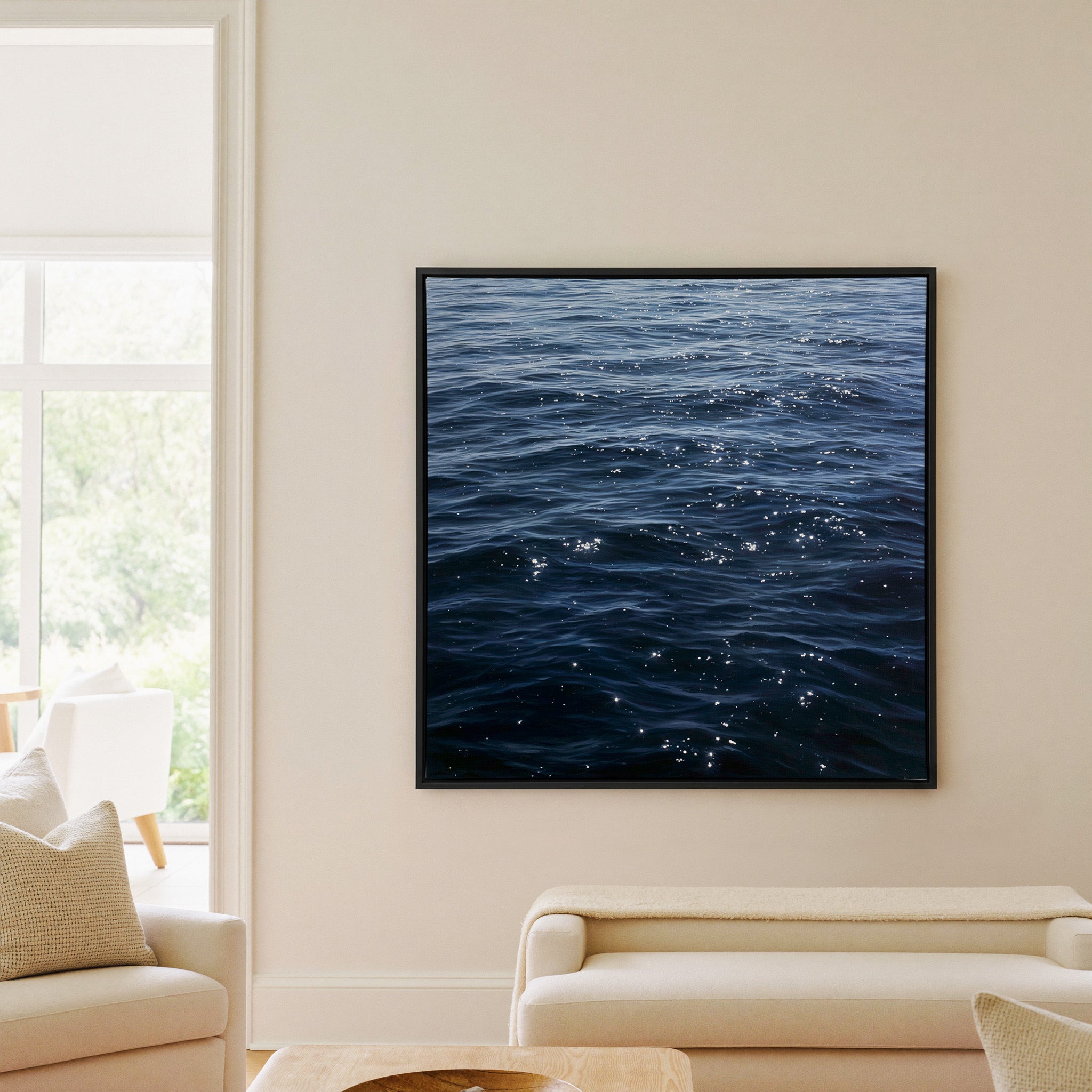 dark blue water with scattered white reflections canvas wall art in a black frame in a living room