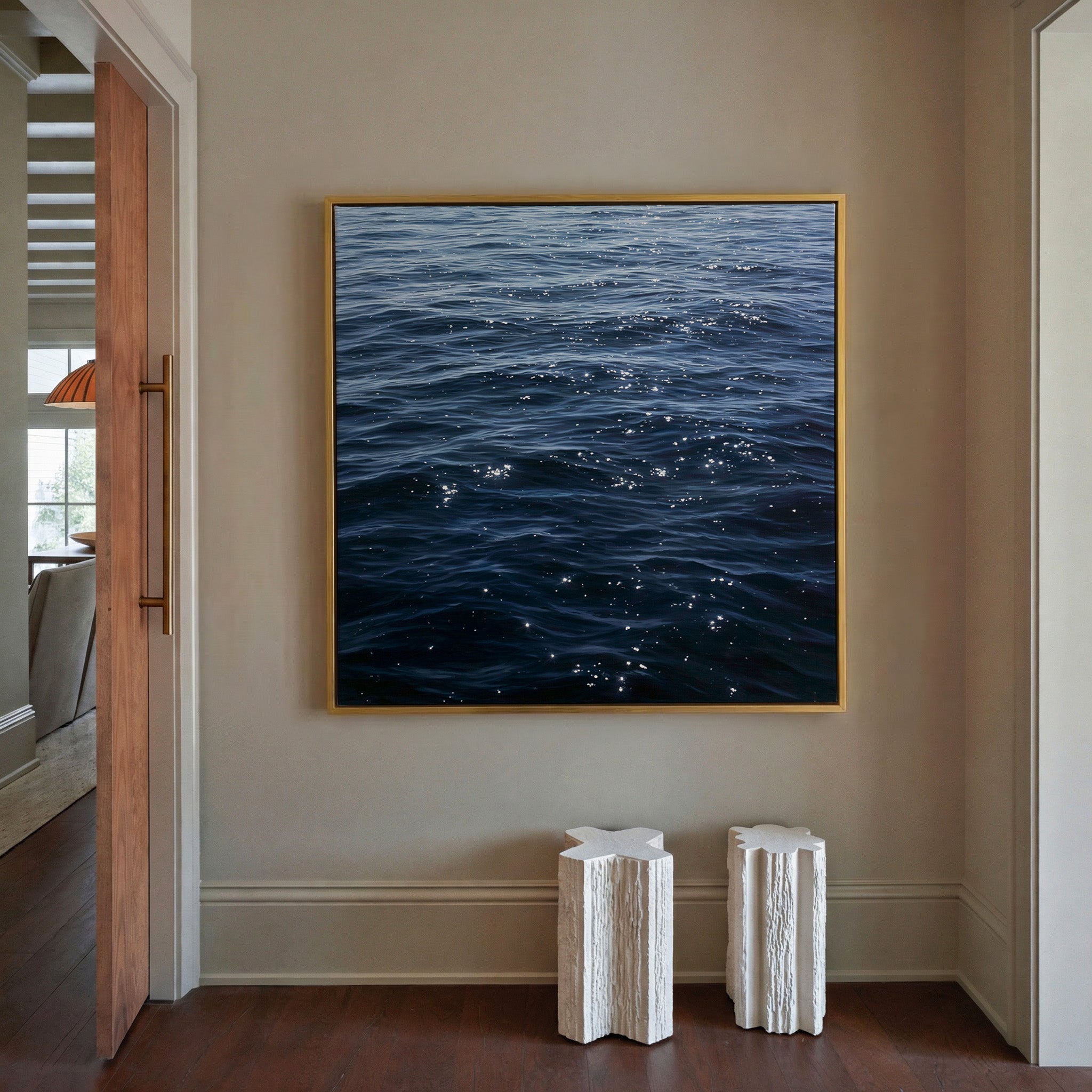 dark blue water with scattered white reflections canvas wall art in a gold frame in a styled room setting