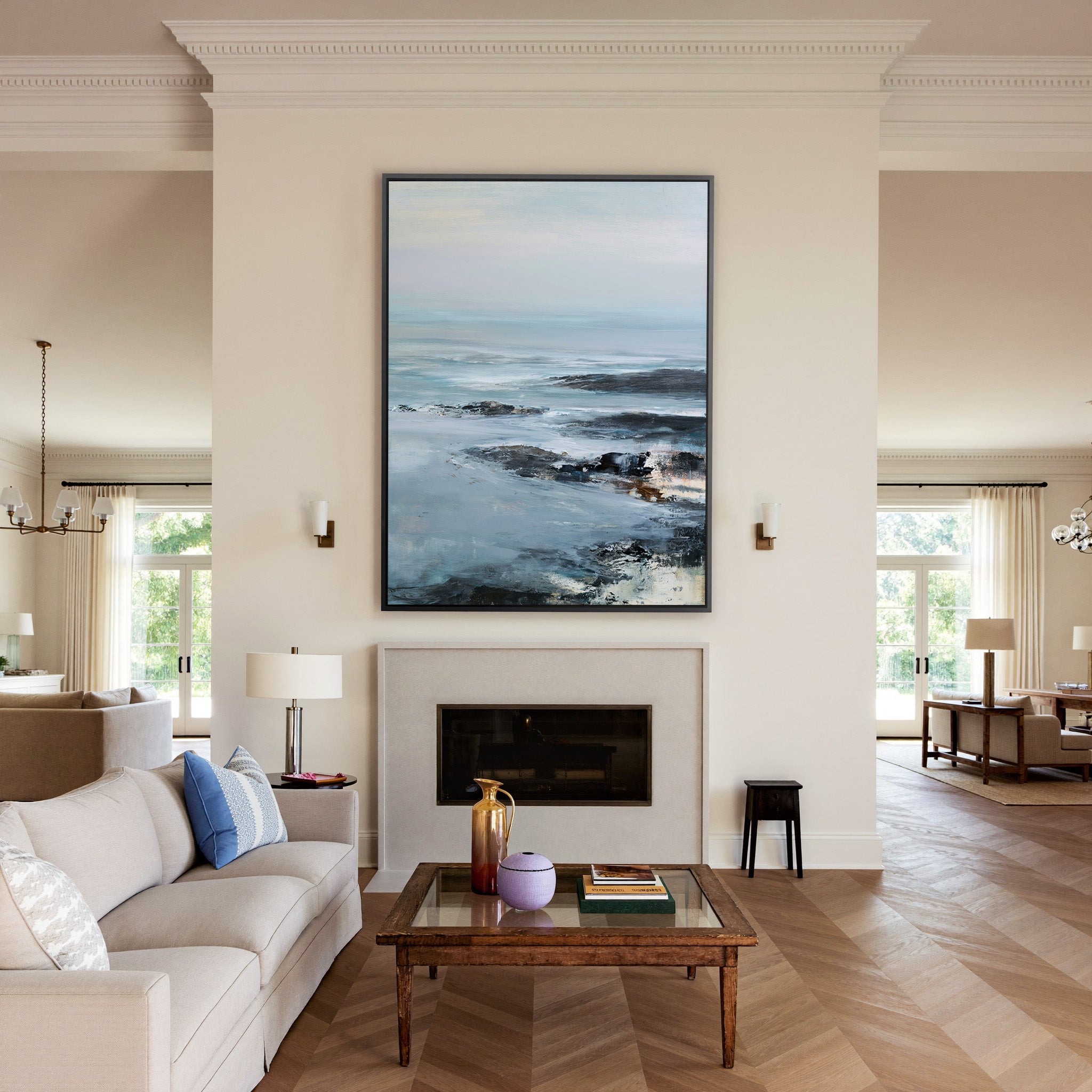 cold northern sea with pale sky and dark rock canvas wall art in a black frame above a mantel