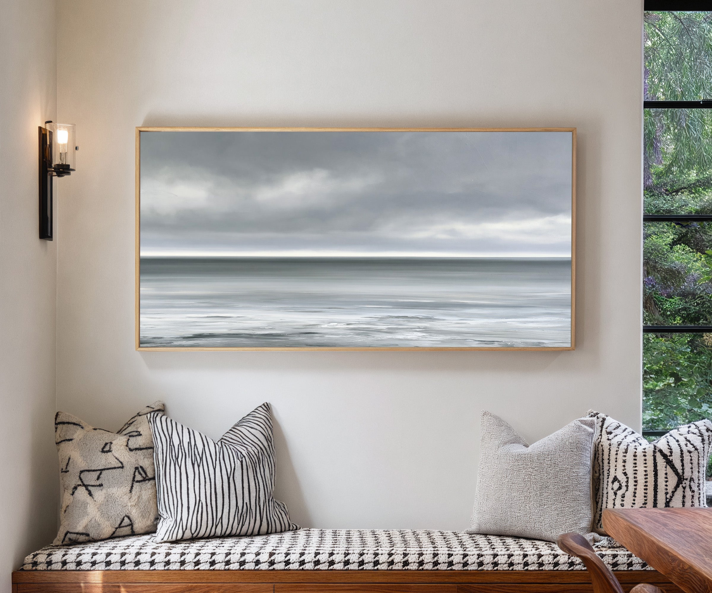 nearly monochrome sea beneath a smoke grey sky canvas wall art in a natural wood frame in a living room