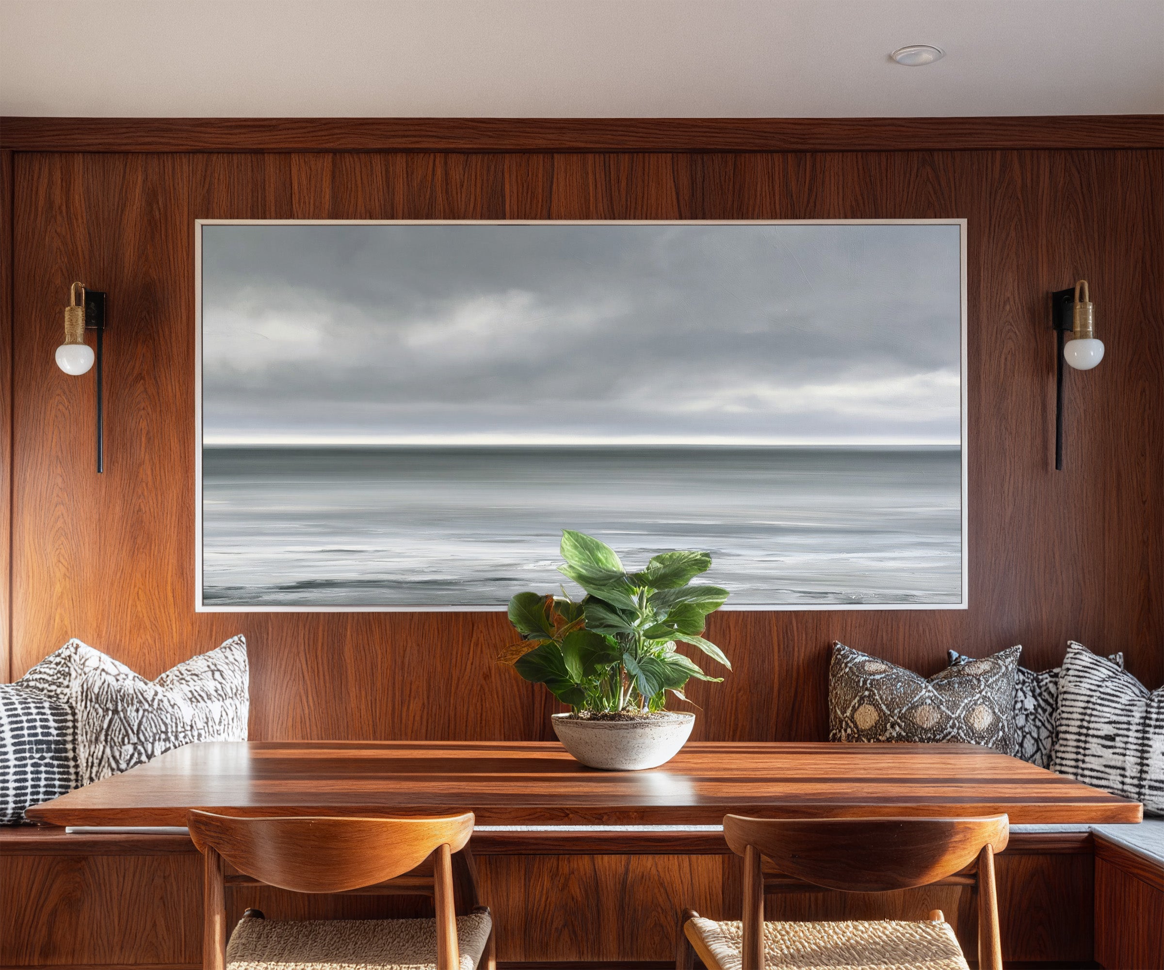 nearly monochrome sea beneath a smoke grey sky canvas wall art in a white frame in a styled room setting