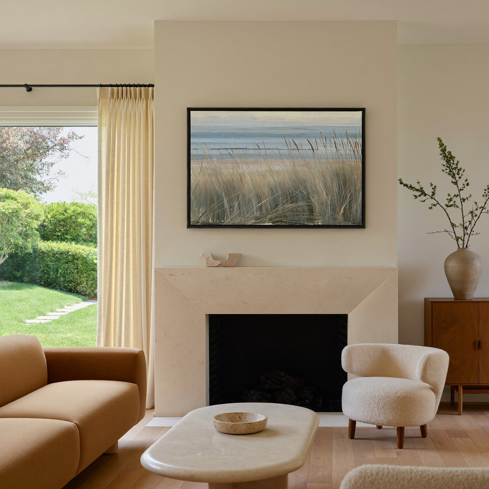 beach grass with blue water and pale dune bands canvas wall art in a black frame above a mantel