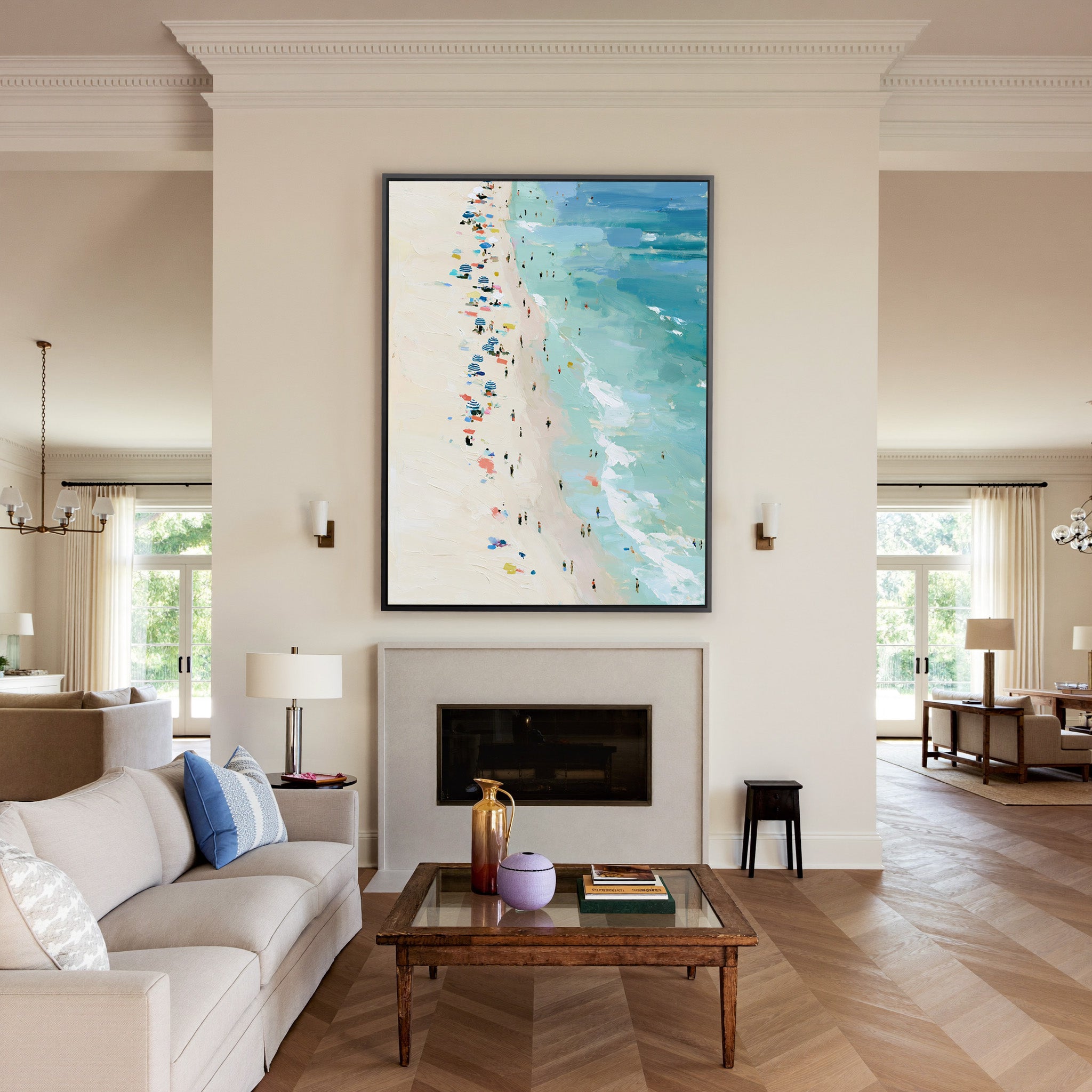 sunlit beach with turquoise water and scattered canvas wall art in a black frame above a mantel