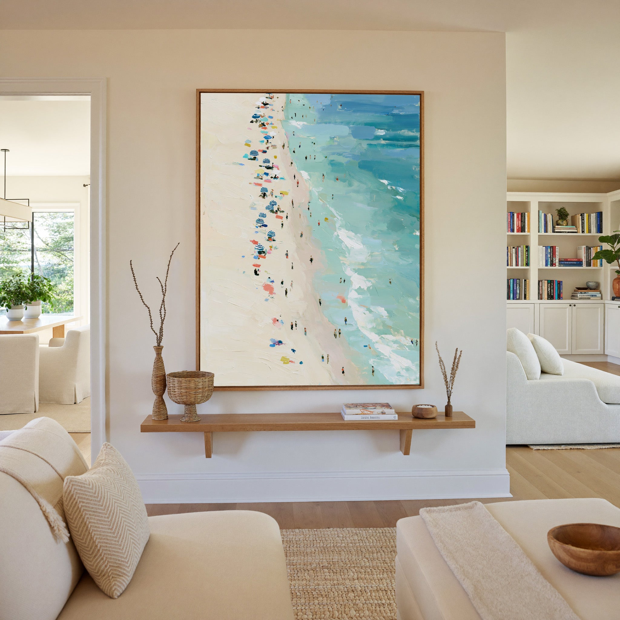 sunlit beach with turquoise water and scattered canvas wall art in an oak frame in a living room