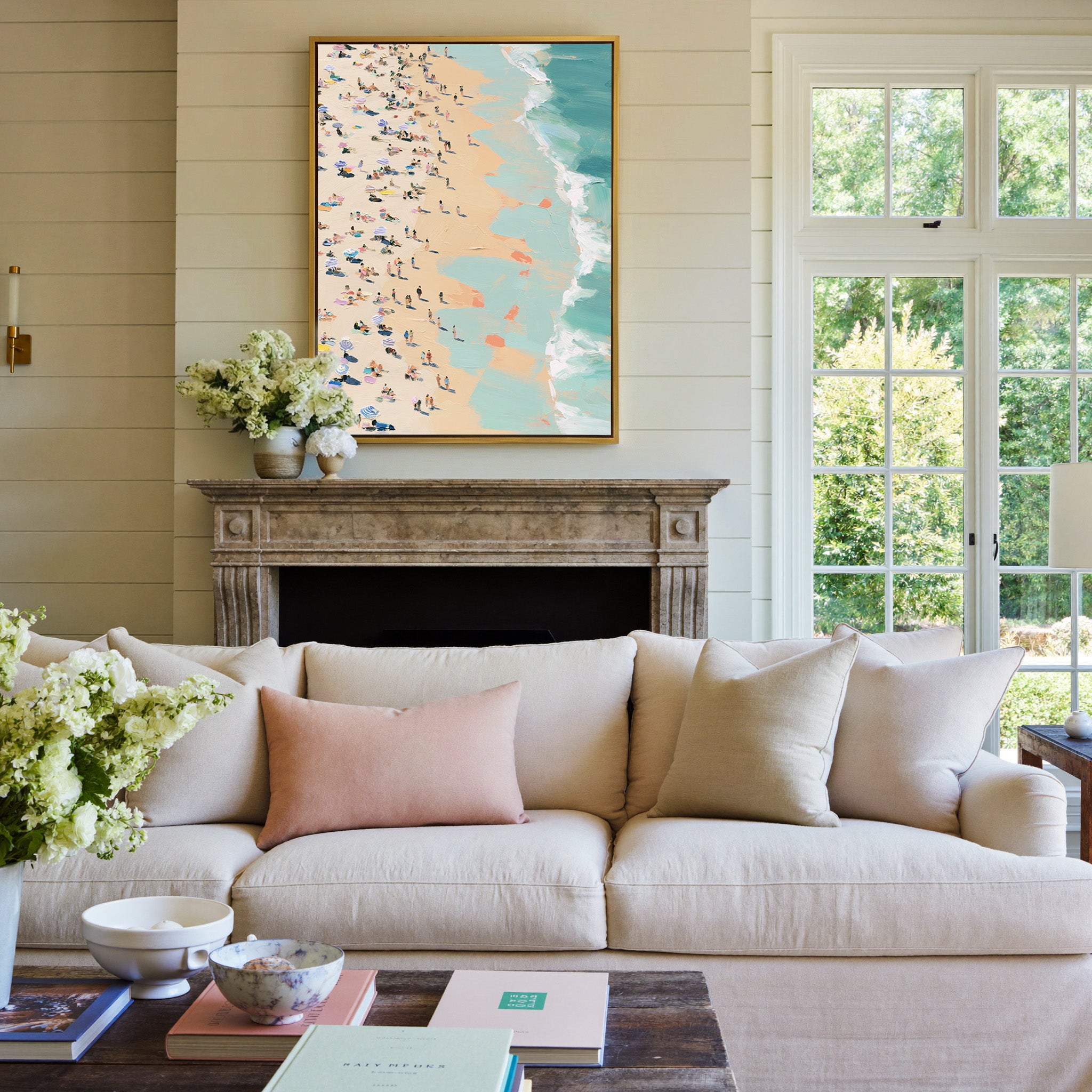 sunlit beach with turquoise surf and scattered canvas wall art in a gold frame above a mantel