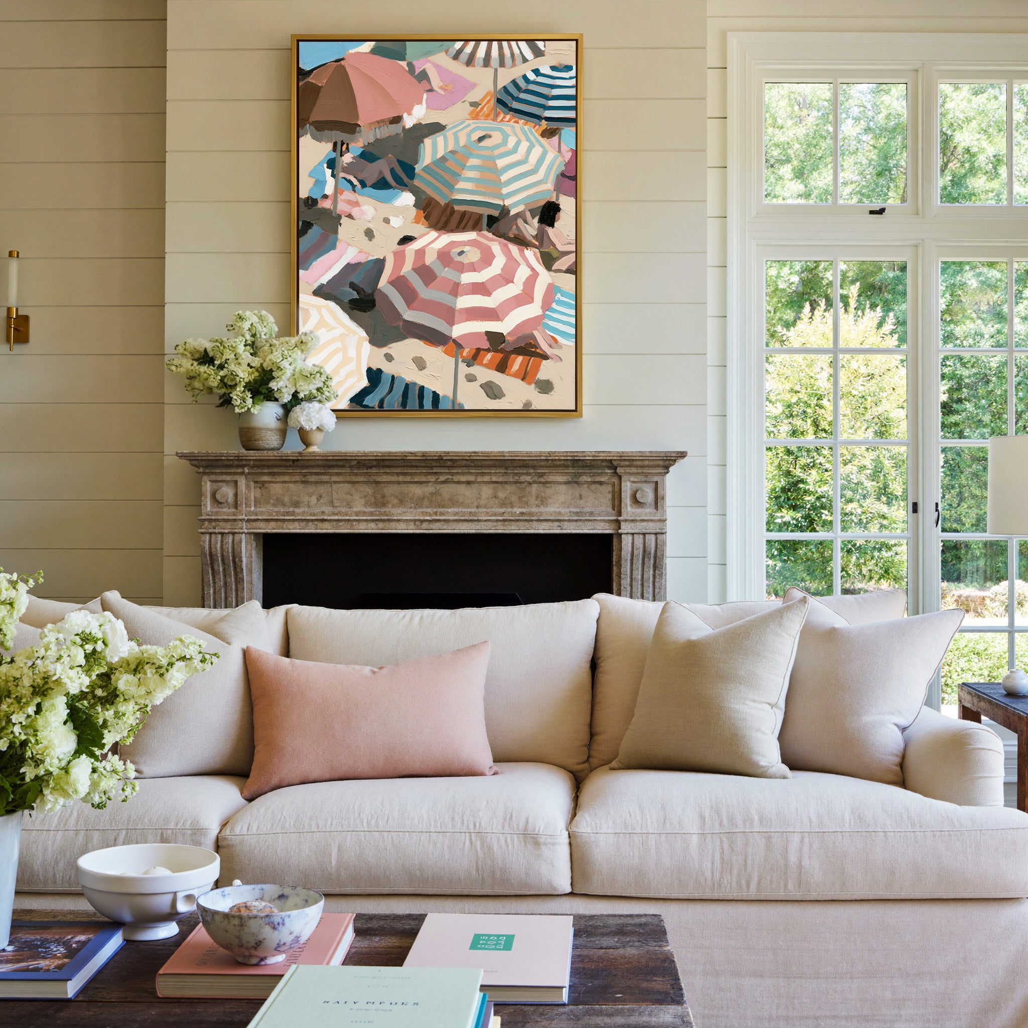 overlapping beach umbrellas in striped pink, canvas wall art in a gold frame above a mantel