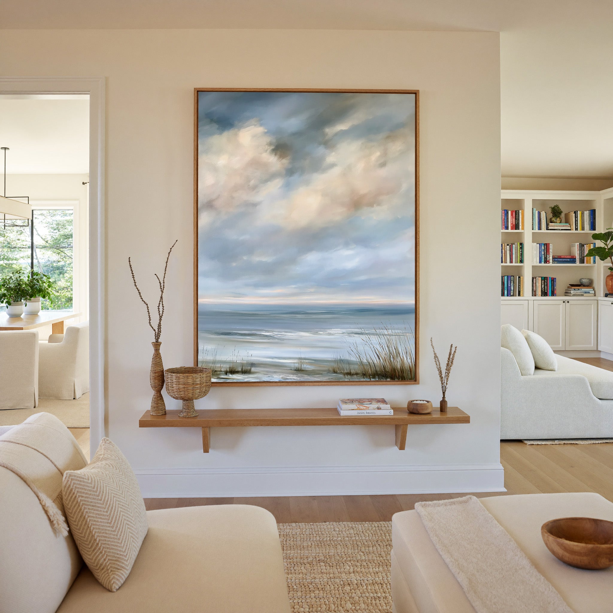 pale coastal horizon beneath broken clouds canvas wall art in an oak frame in a living room