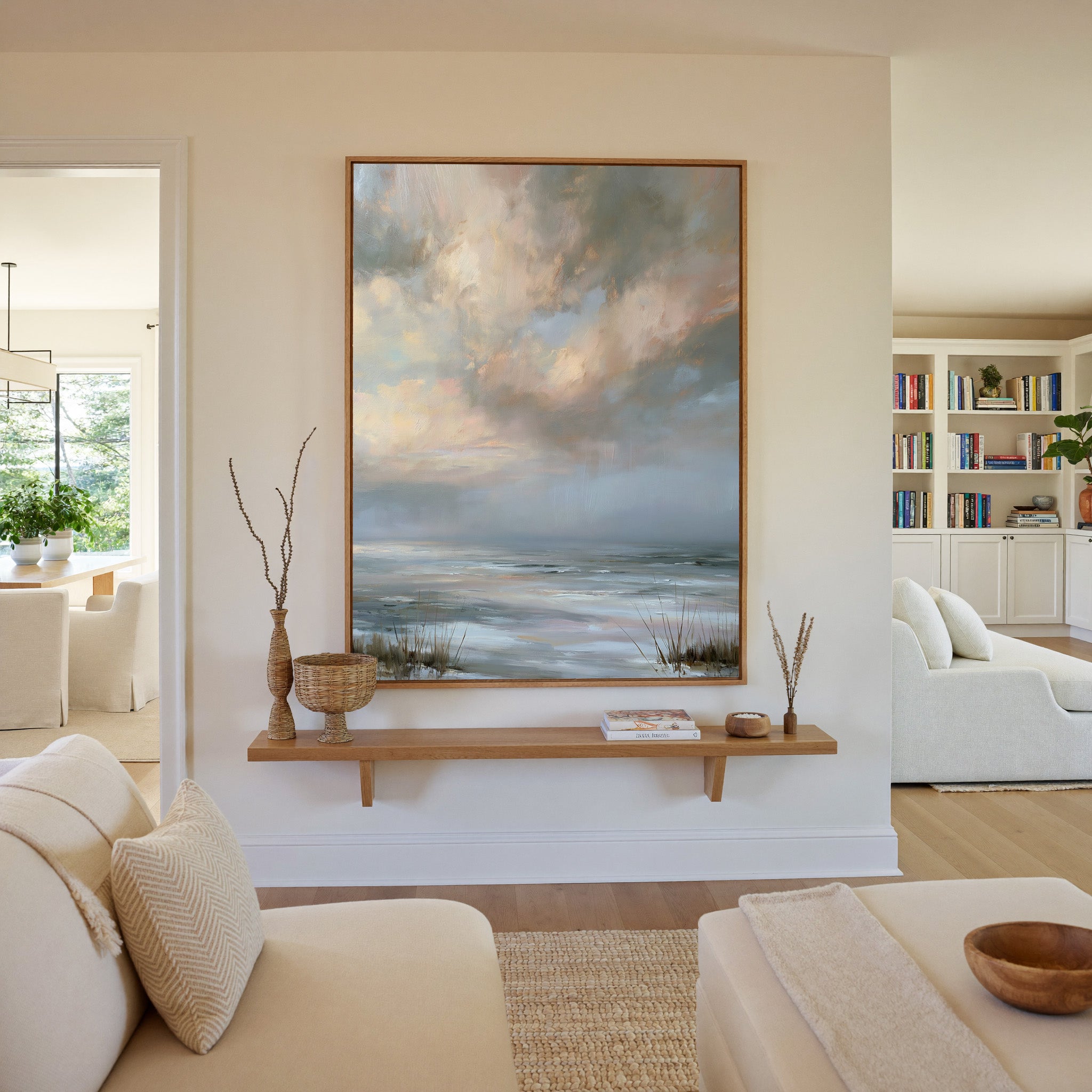 pale coastal horizon beneath broken clouds canvas wall art in an oak frame in a living room