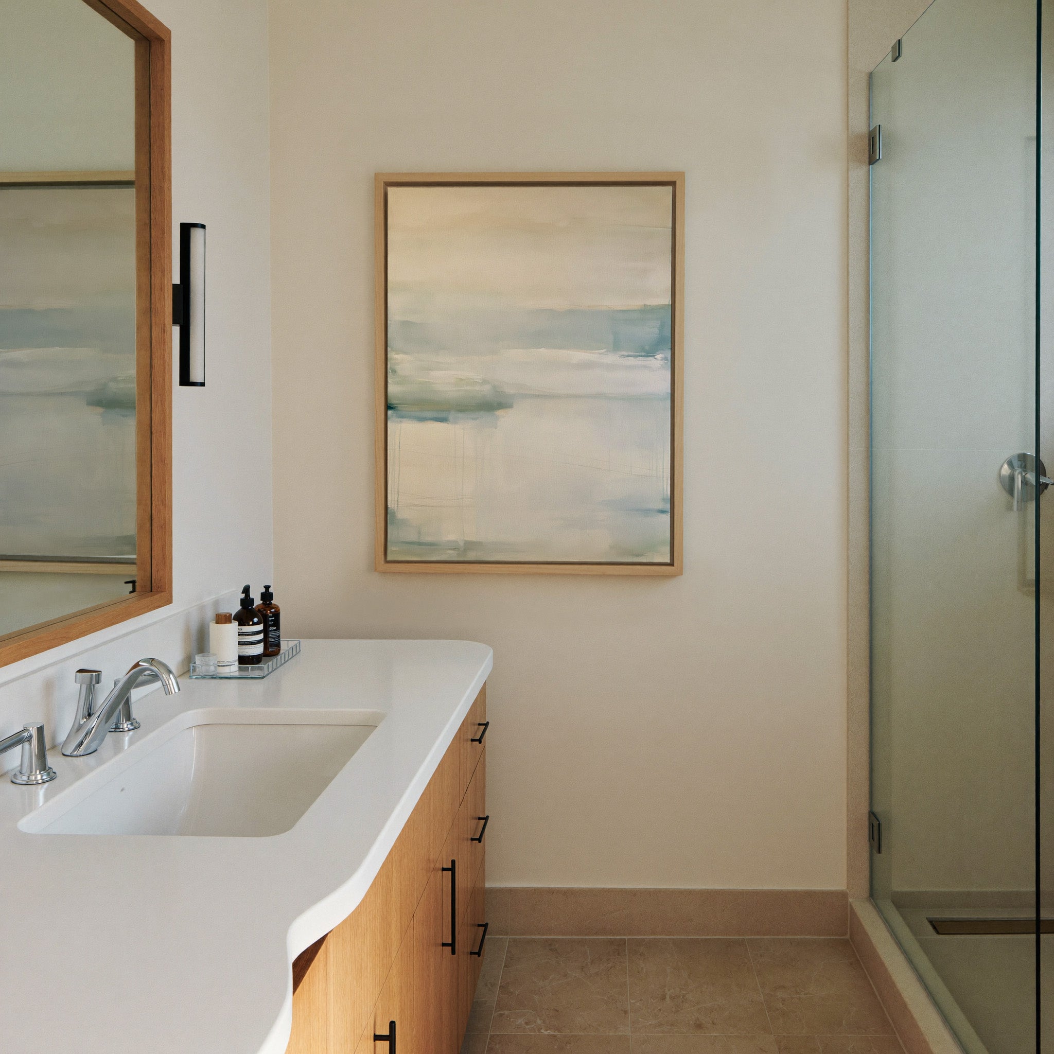 soft cream and blue abstract with misty canvas wall art in a natural wood frame in a styled room setting