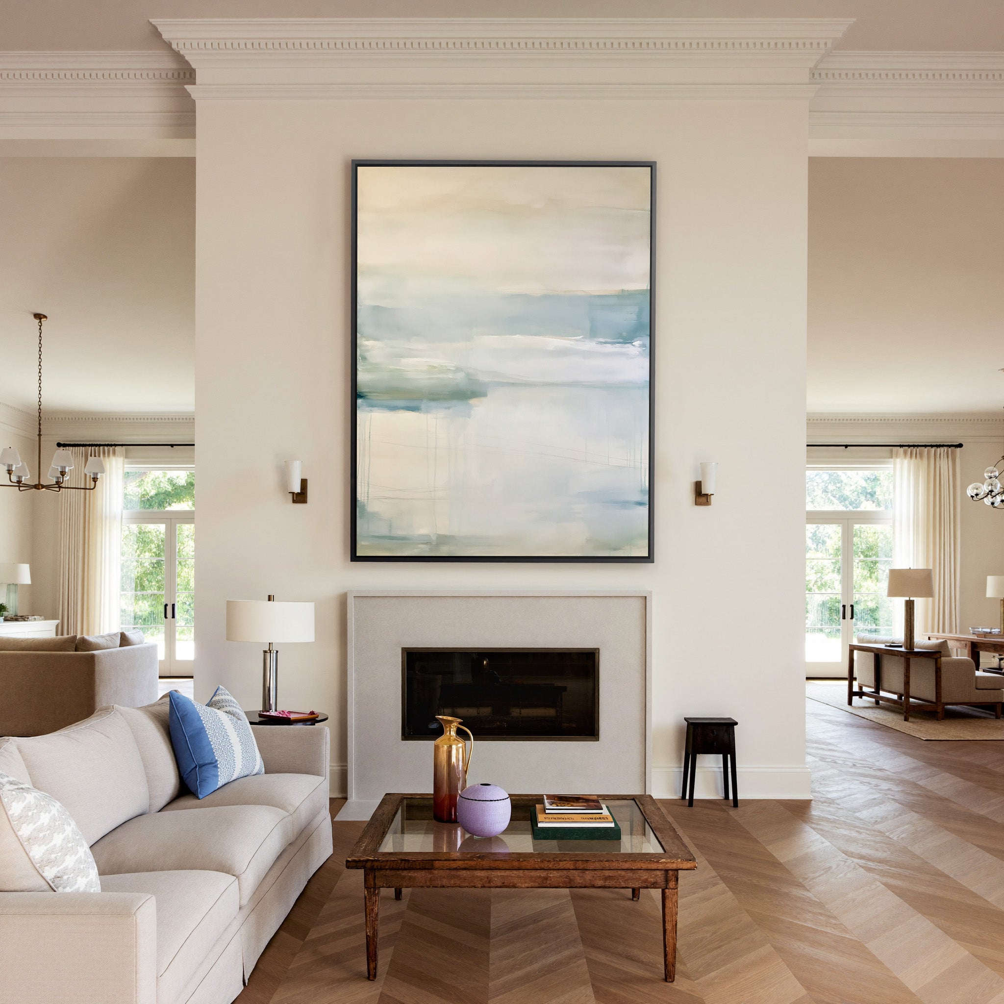 soft cream and blue abstract with misty canvas wall art in a black frame above a mantel