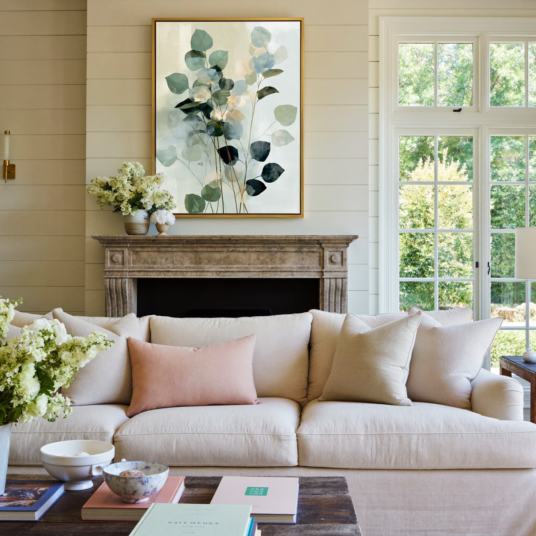 soft eucalyptus like leaves in blue green and canvas wall art in a gold frame above a mantel