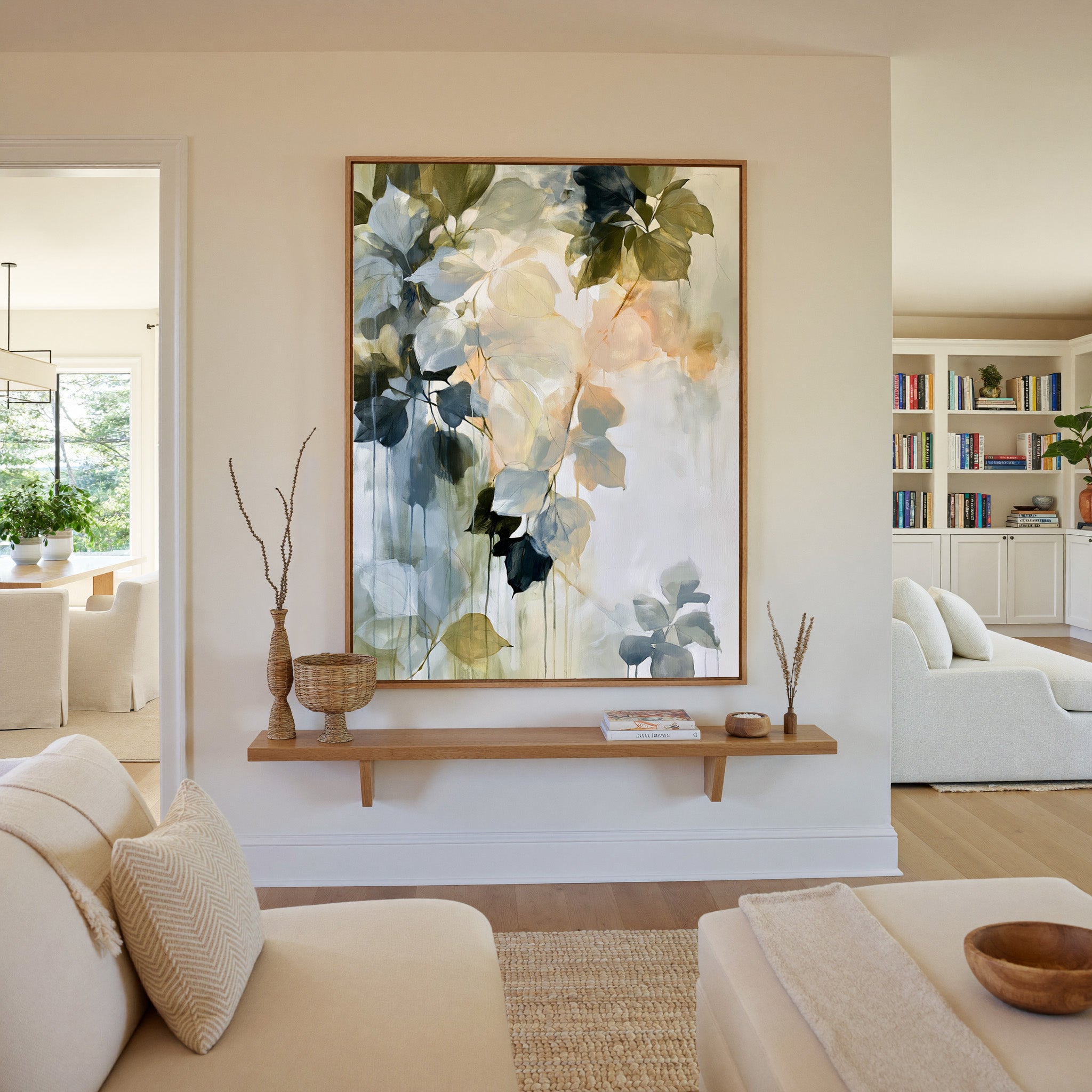 soft blue, sage, cream, and peach leaf forms canvas wall art in an oak frame in a living room