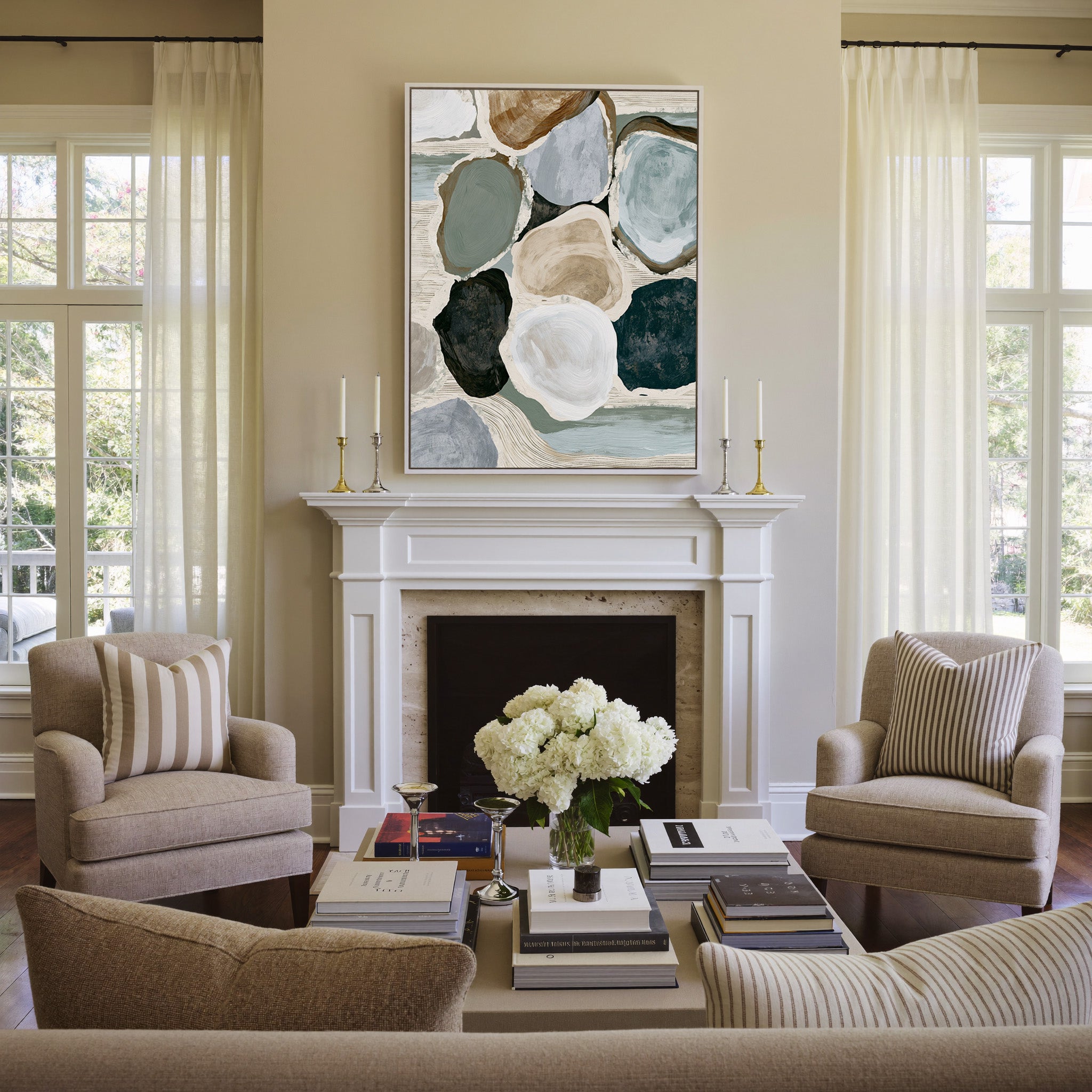 muted coastal abstract with oyster shell shapes canvas wall art in a white frame above a mantel