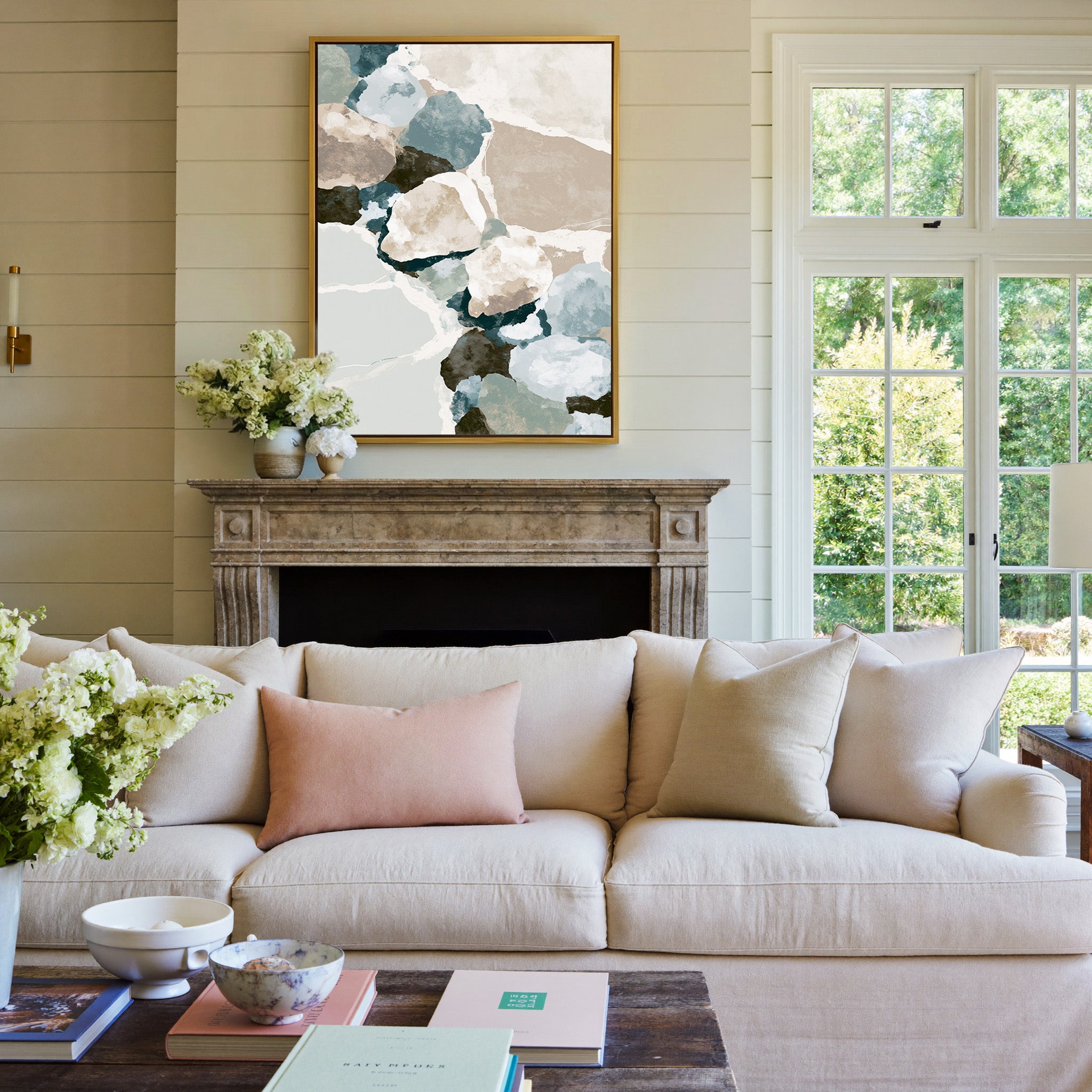 muted coastal abstract with oyster shell shapes canvas wall art in a gold frame above a mantel