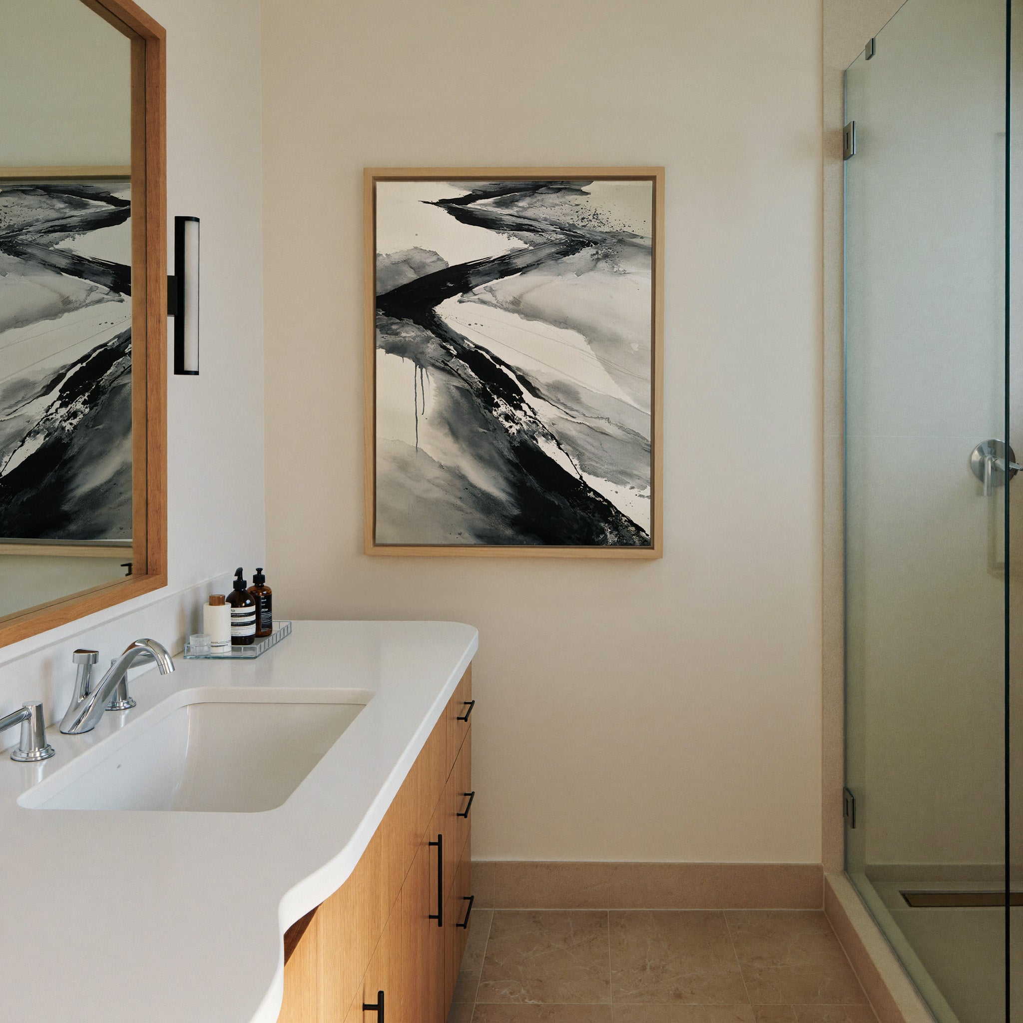 black and gray flowing abstract canvas wall art in a natural wood frame in a styled room setting