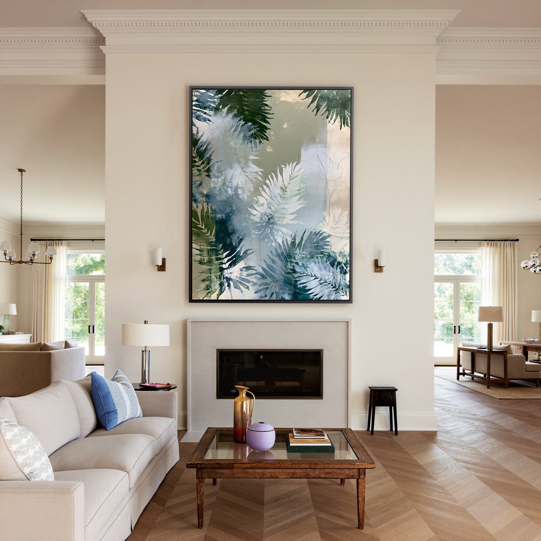 layered fern leaves in sage, blue gray, and canvas wall art in a black frame above a mantel