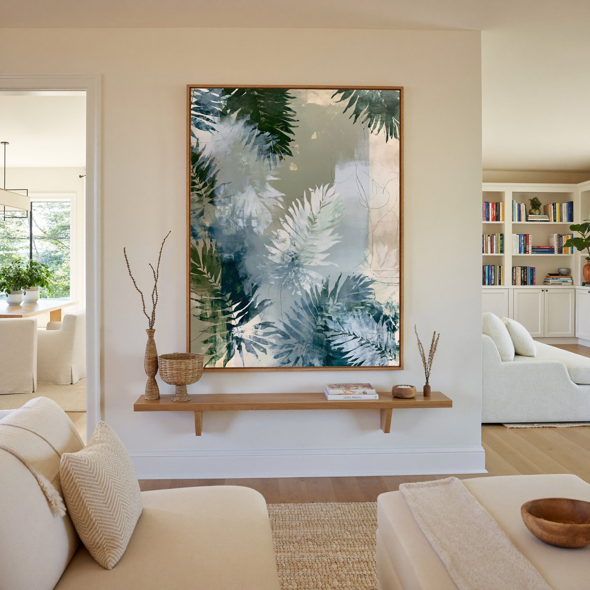 layered fern leaves in sage, blue gray, and canvas wall art in an oak frame in a living room