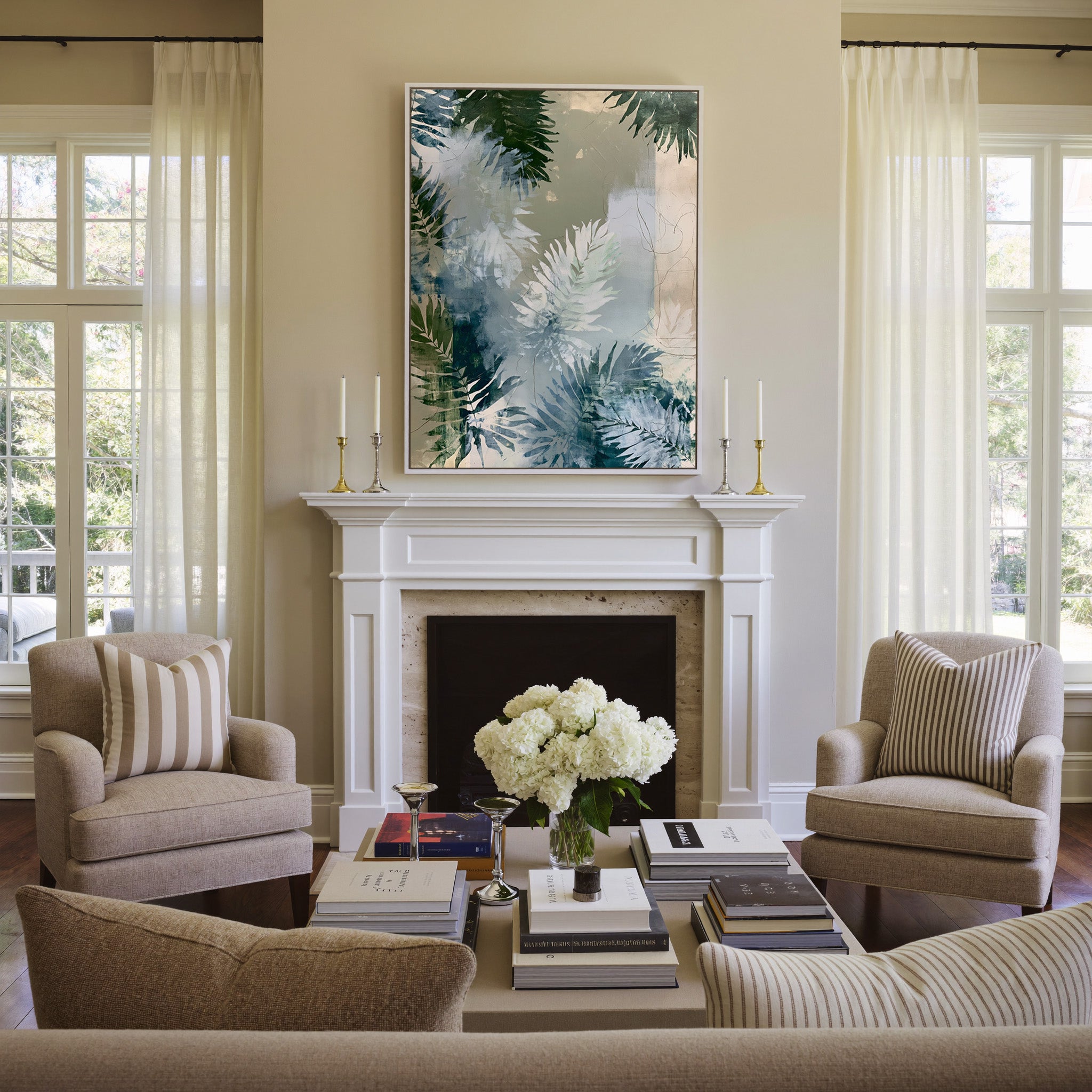 layered fern leaves in sage, blue gray, and canvas wall art in a white frame above a mantel