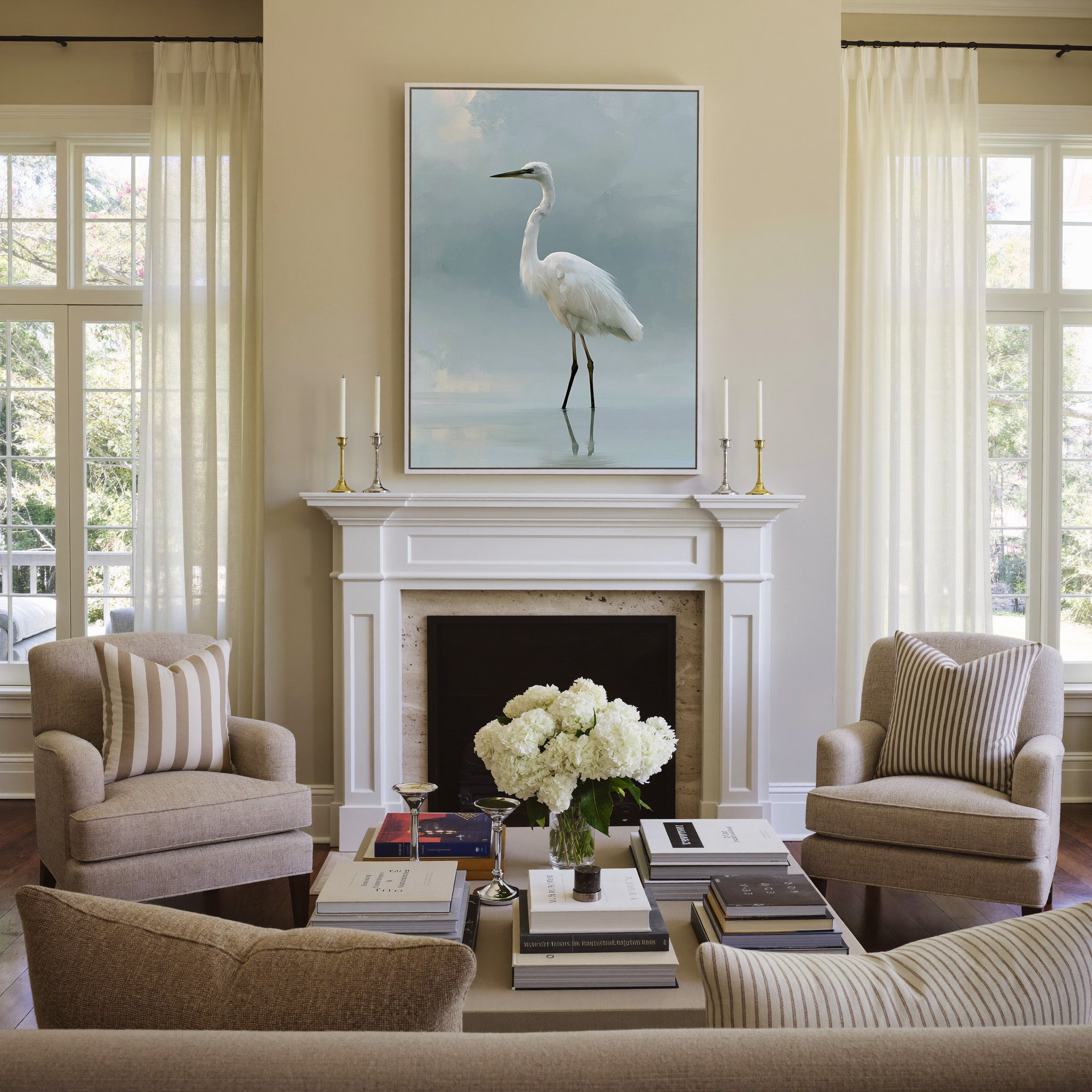 white heron standing in pale reflective water canvas wall art in a white frame above a mantel