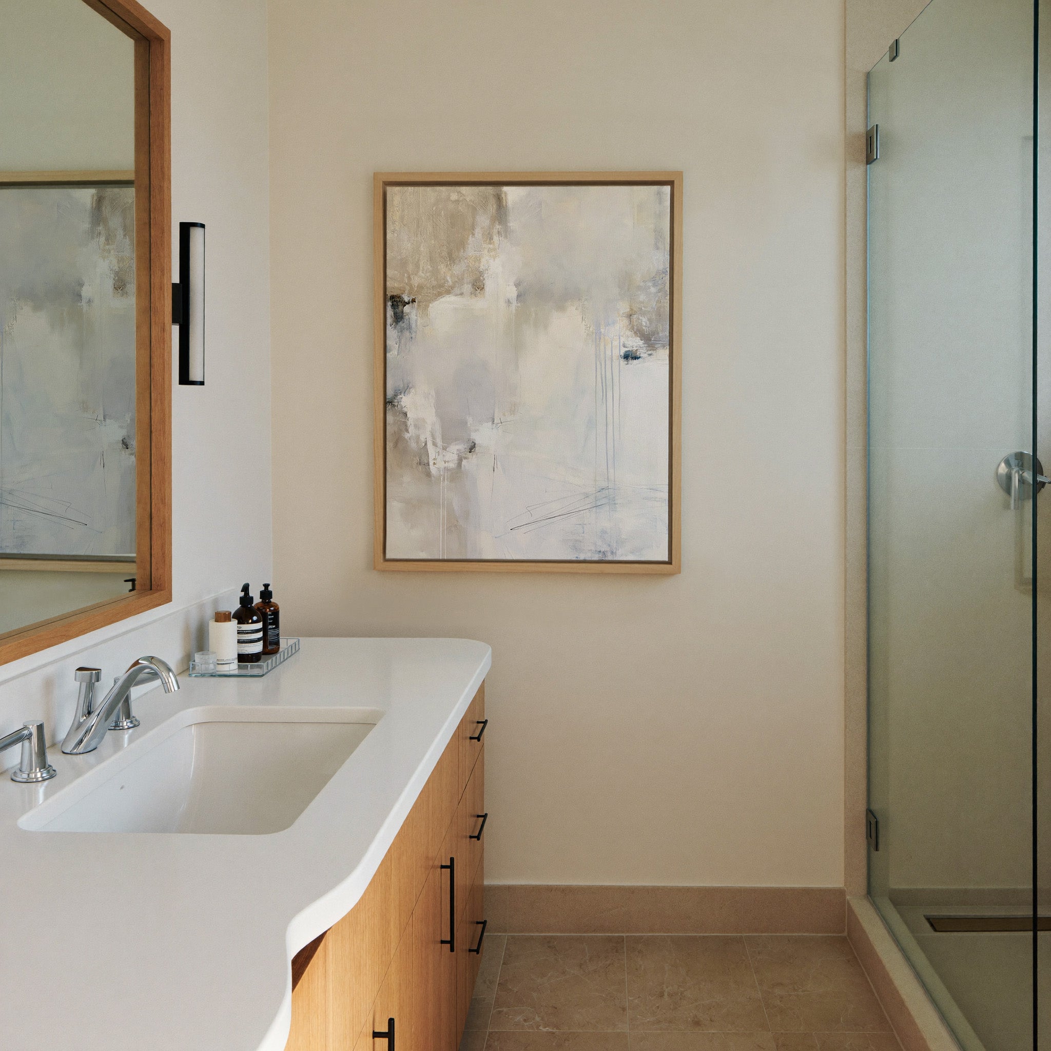 soft white and beige abstract with pale blue canvas wall art in a natural wood frame in a styled room setting