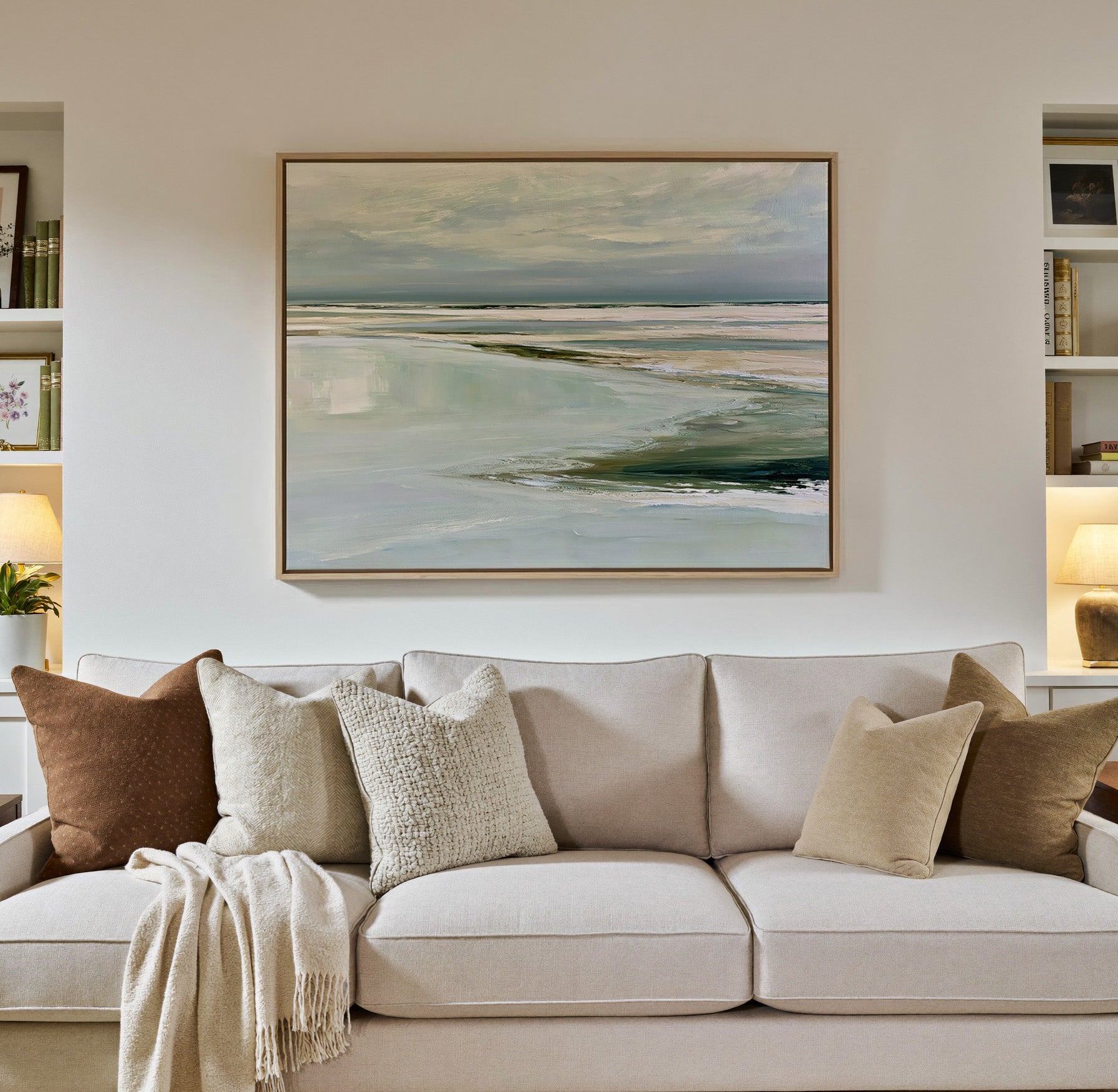 pale reflective shoreline with low horizontal canvas wall art in a natural wood frame in a styled room setting