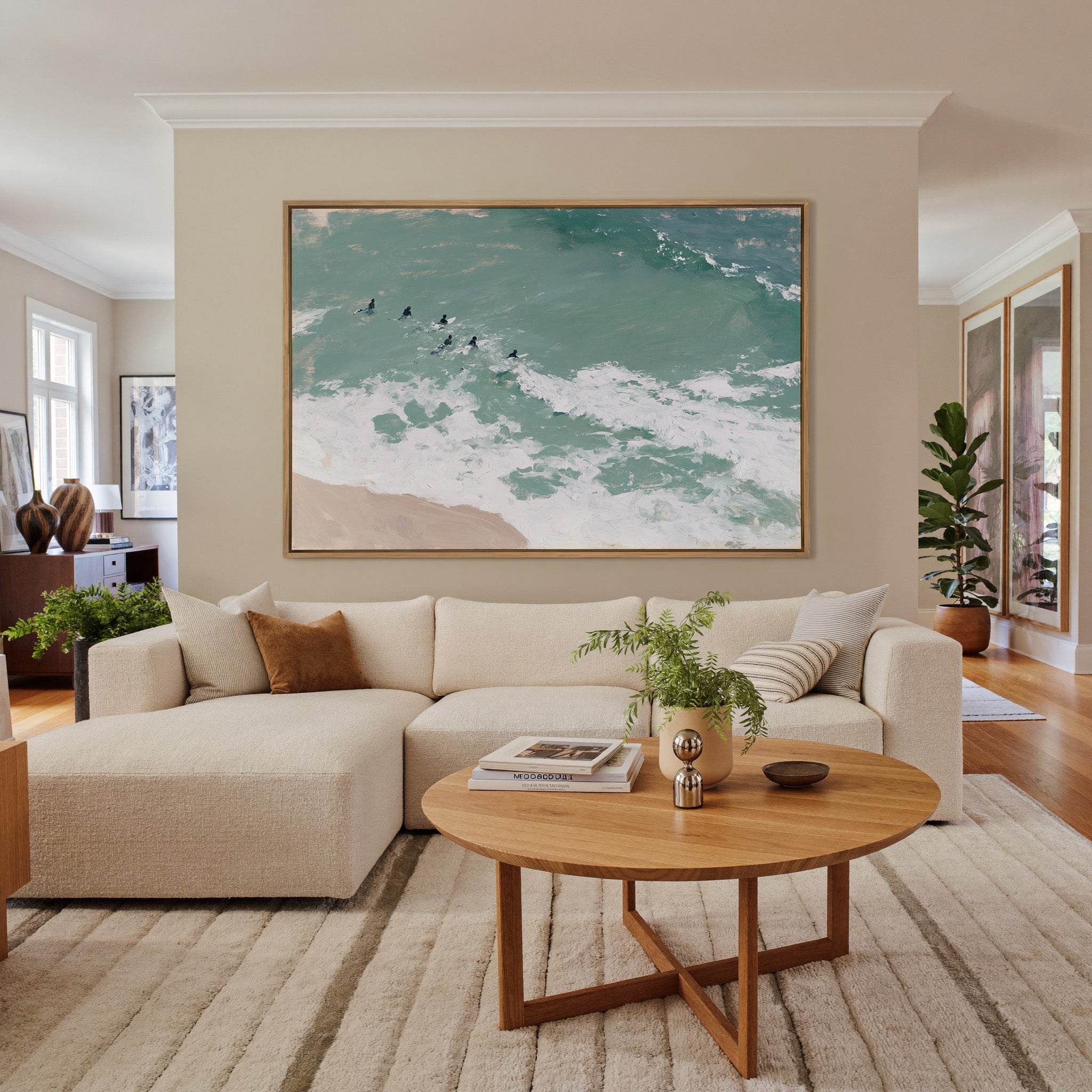 turquoise surf with small figures beyond the canvas wall art in an oak frame in a living room