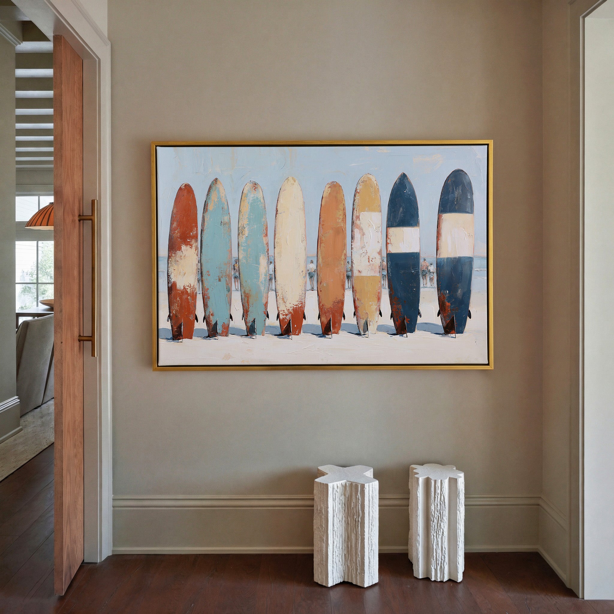 row of colorful surfboards on pale sand canvas wall art in a gold frame in a styled room setting