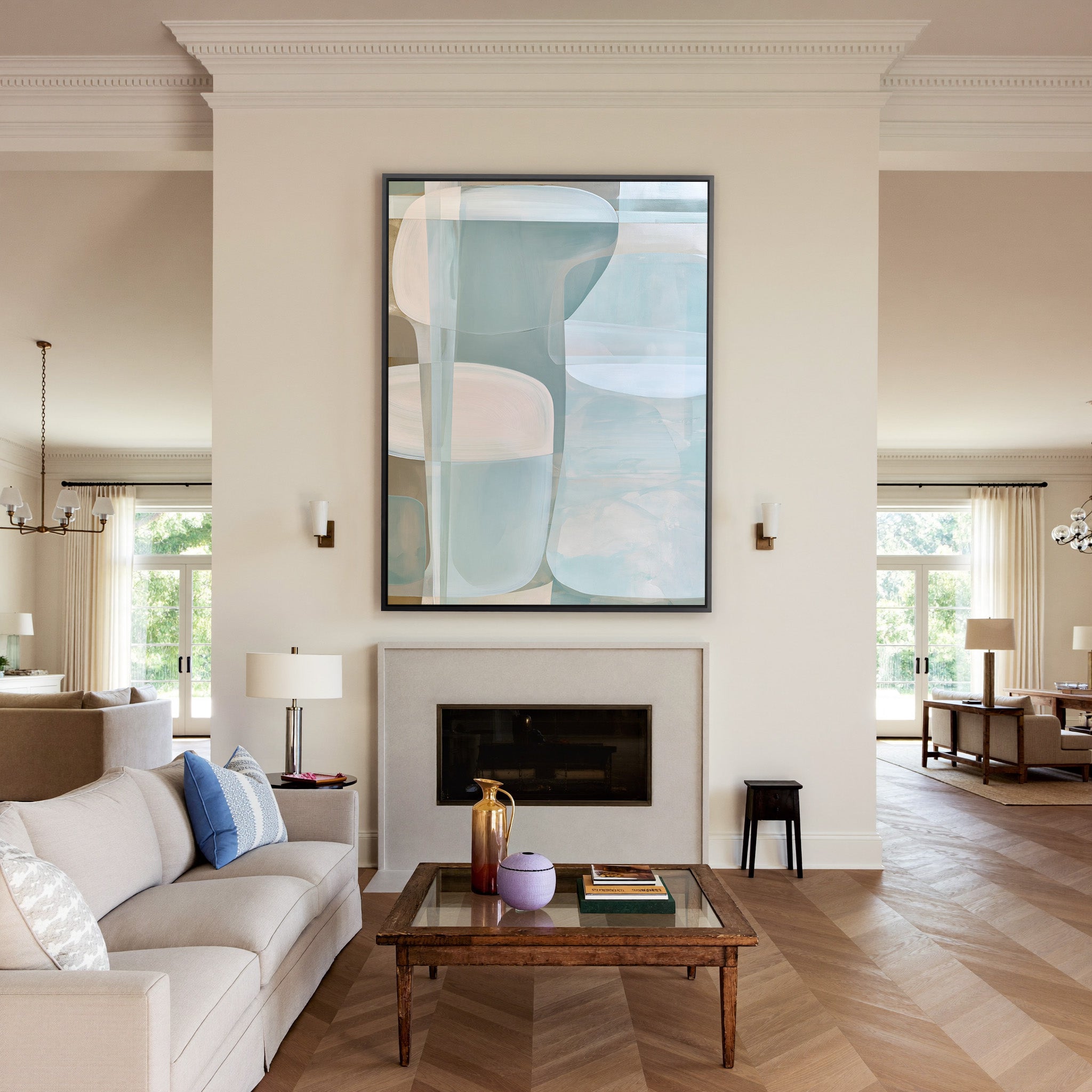 soft blue and beige abstract with rounded canvas wall art in a black frame above a mantel