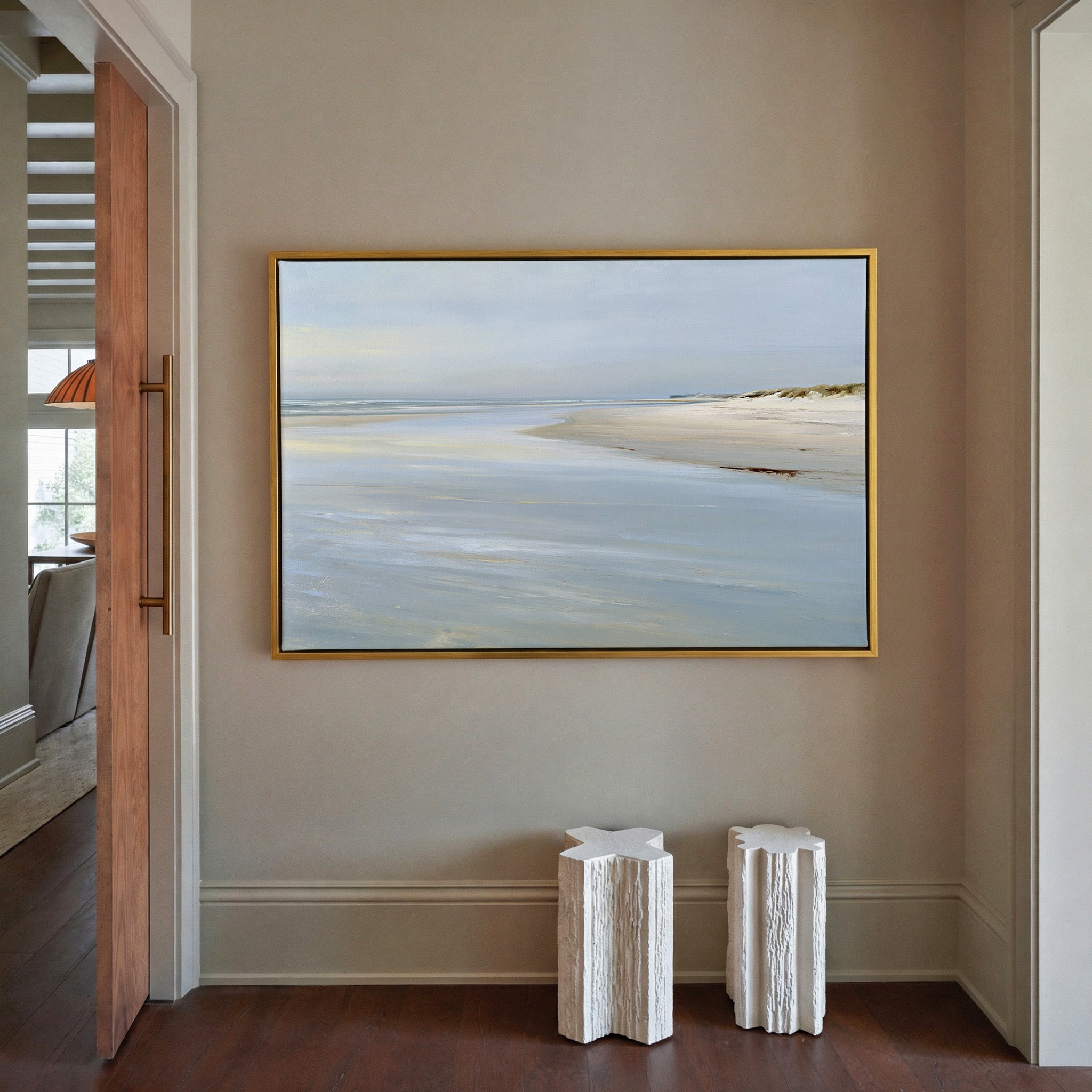 pale shoreline with wet sand and a low horizon canvas wall art in a gold frame in a styled room setting